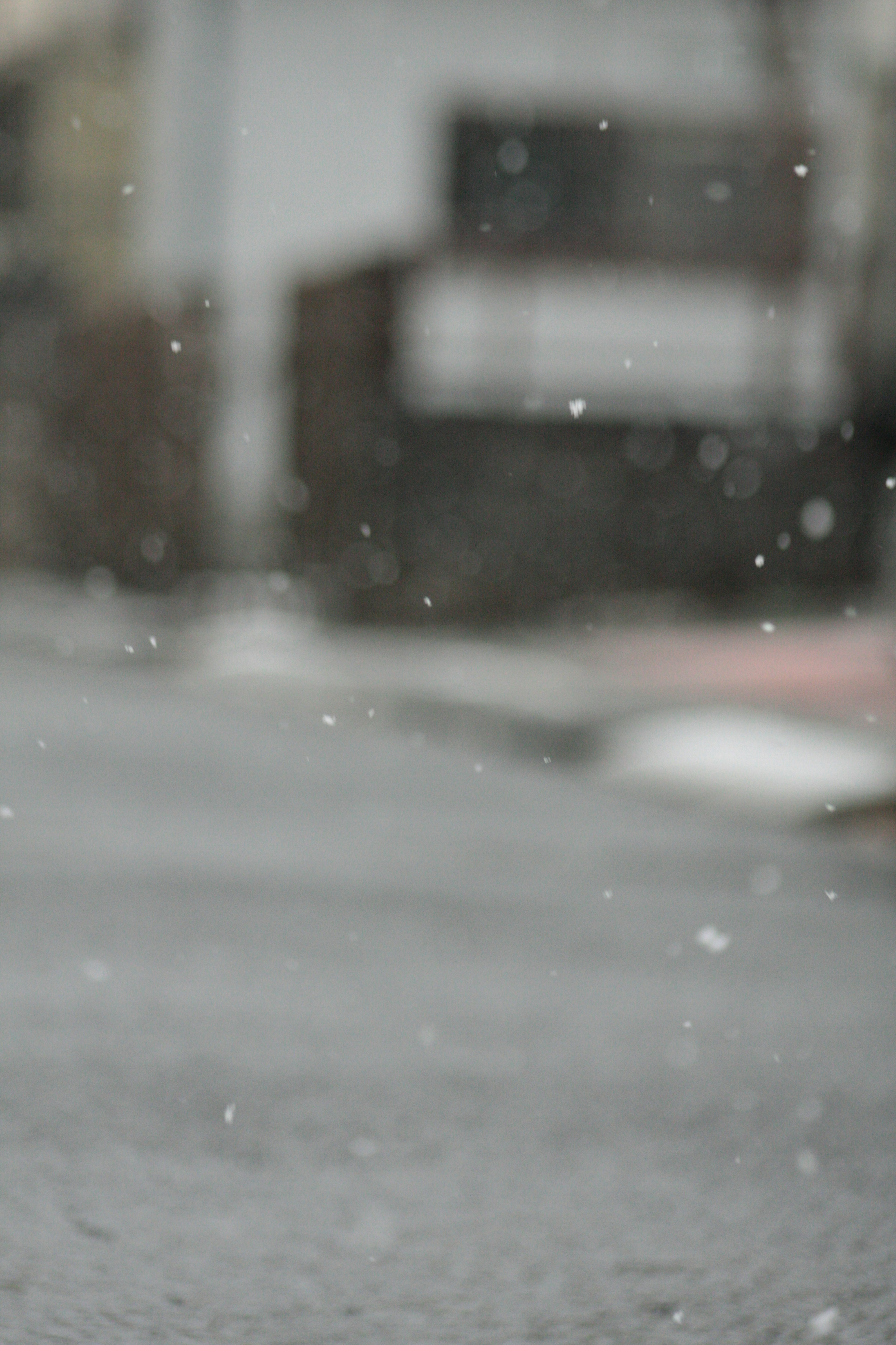 Snow falling in a street scene with a blurred background