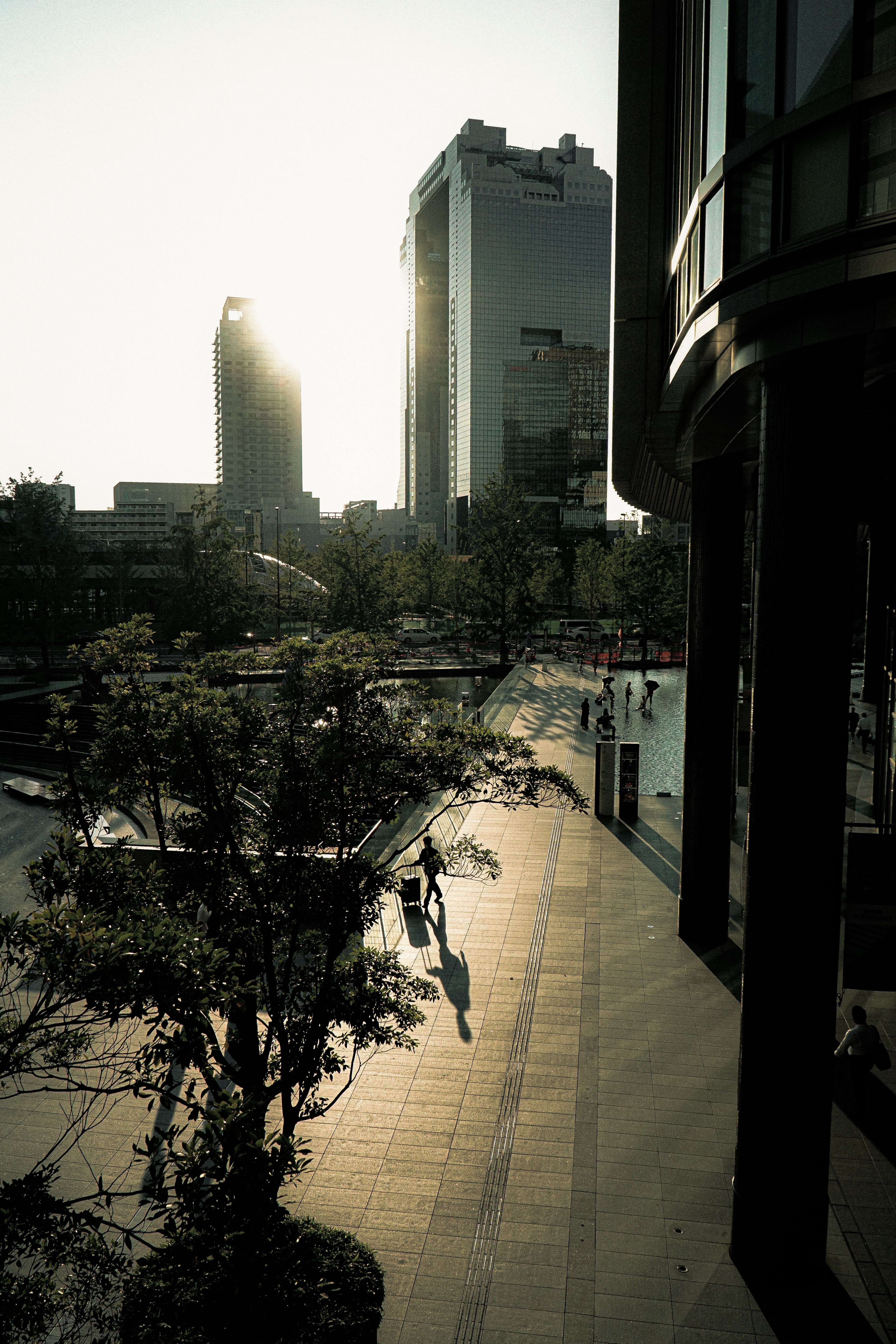 Paisaje urbano con personas caminando bajo un atardecer