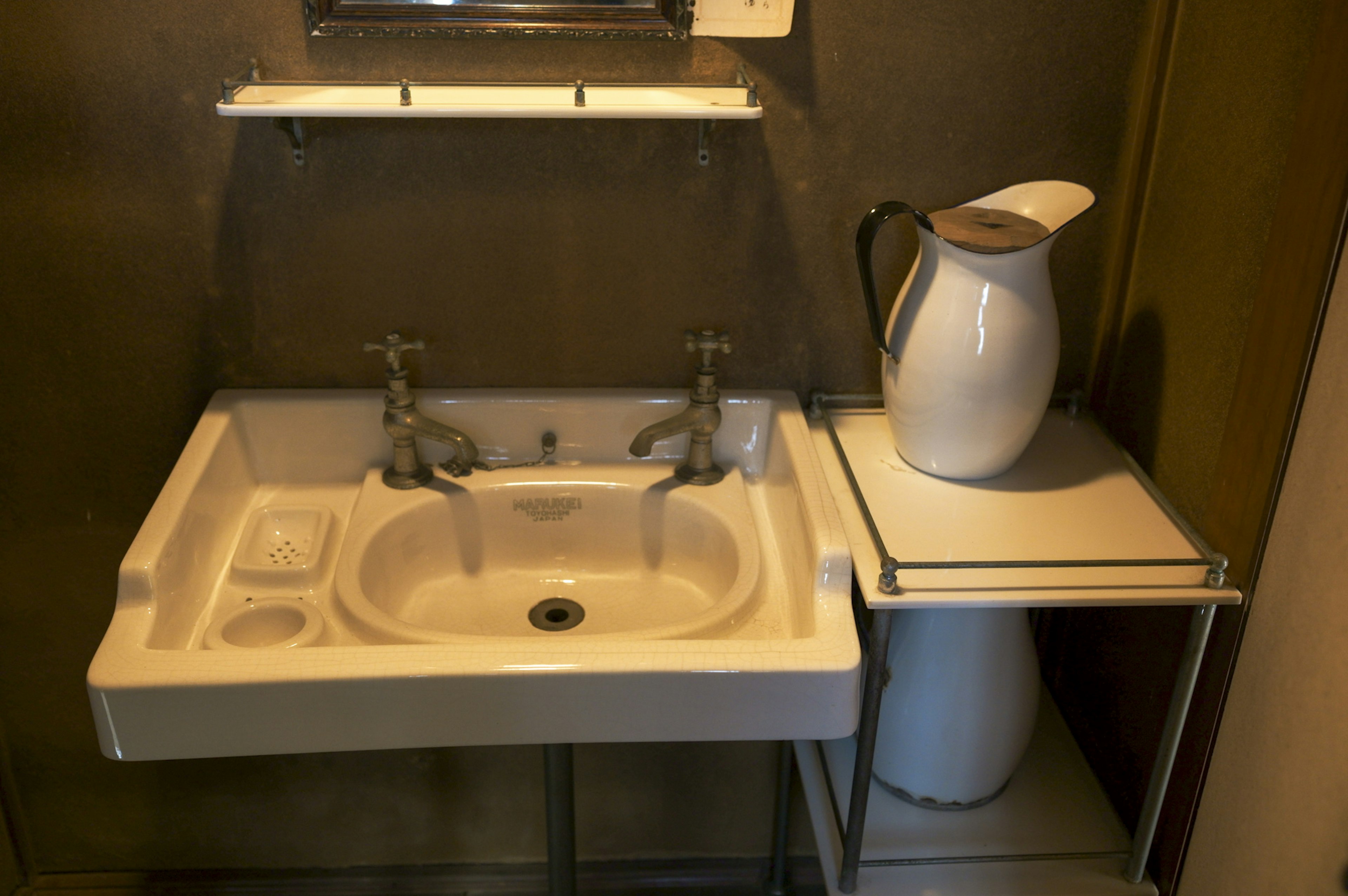 Simple white sink with silver faucets in a corner of a bathroom