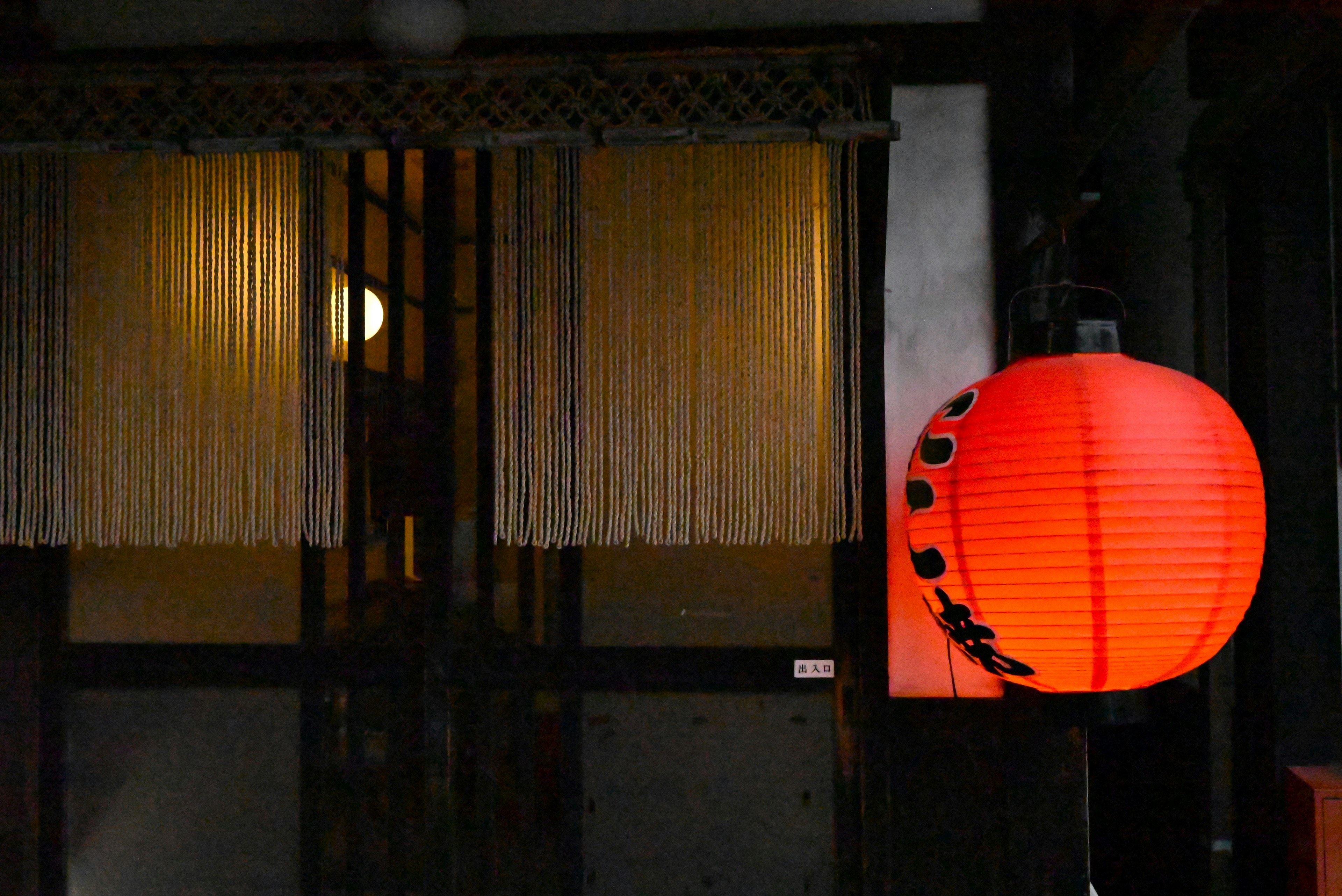 Linterna roja iluminando la entrada de un edificio japonés tradicional