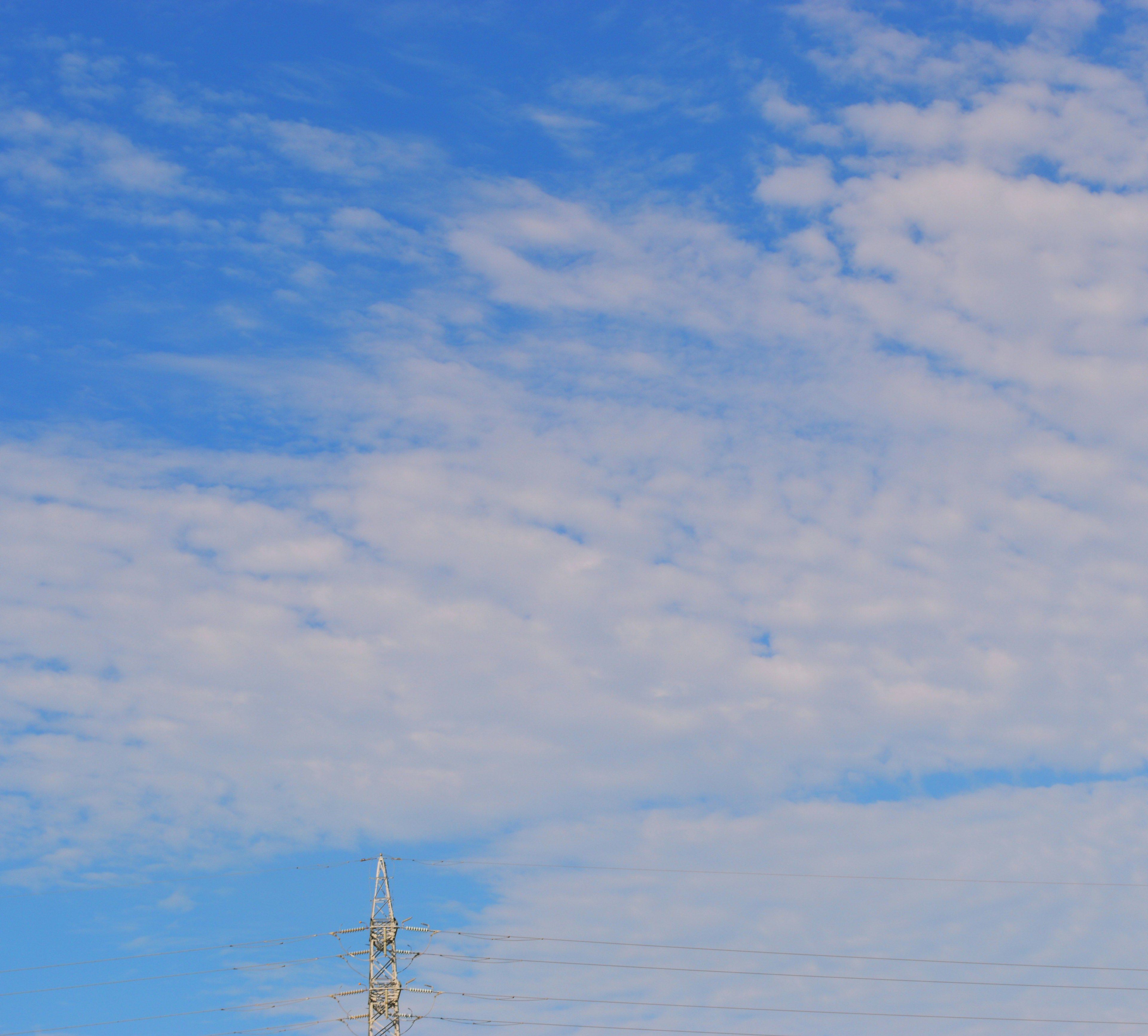 Lanskap dengan langit biru dan awan putih dengan menara komunikasi