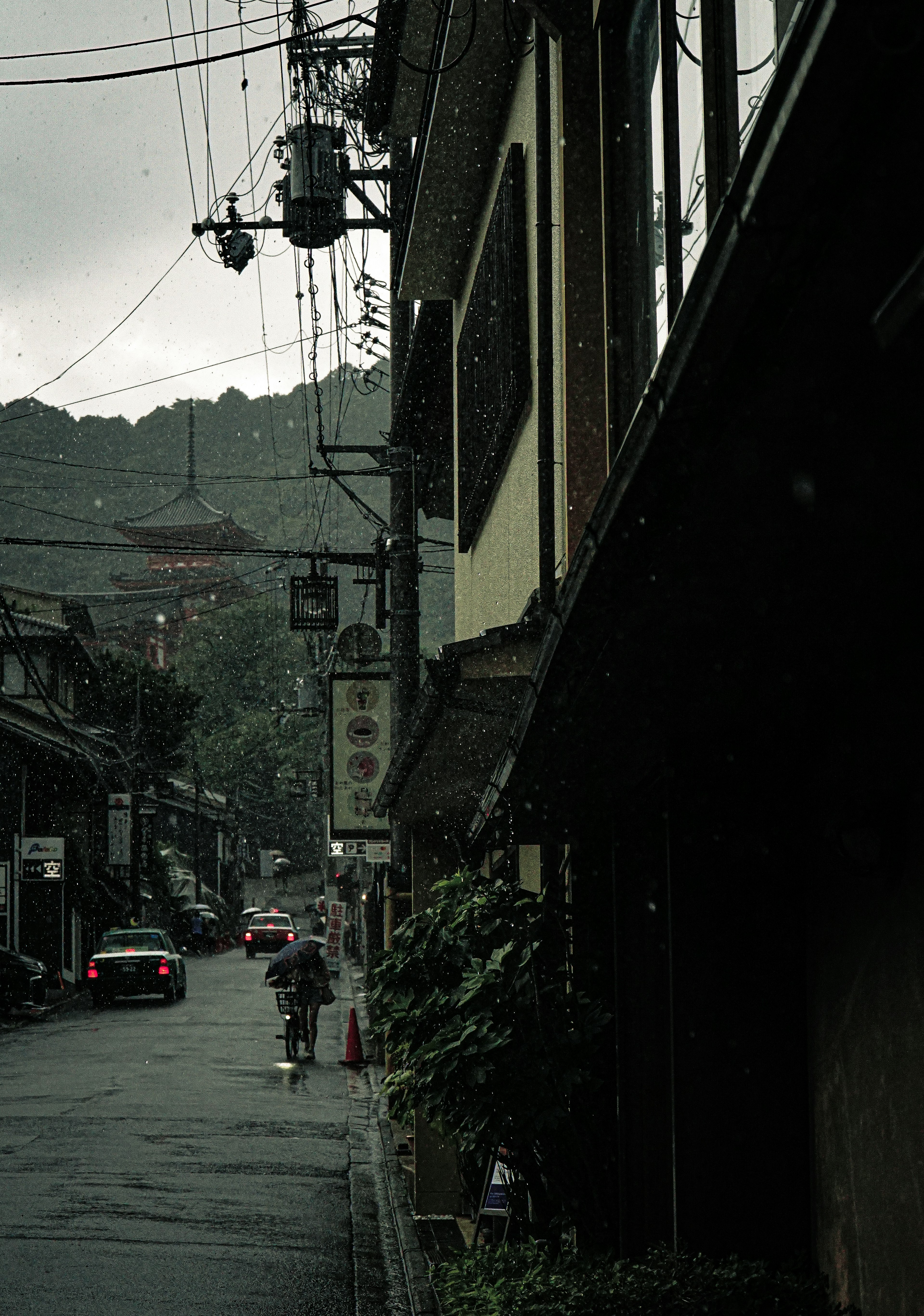 雨の降る街並みの風景 古い建物と電線が並ぶ情景