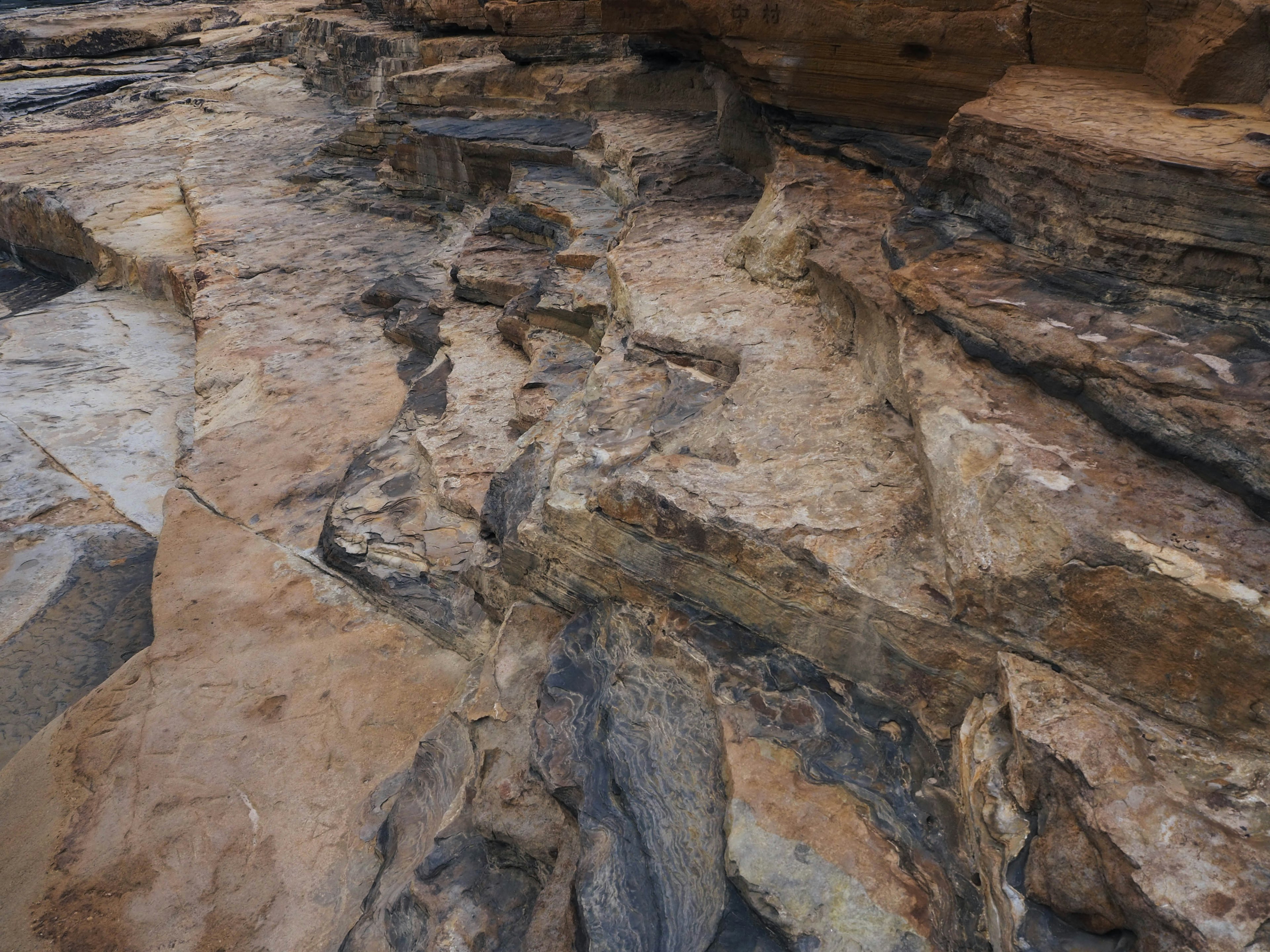 Primo piano di strati di roccia testurizzati che mostrano diversi colori