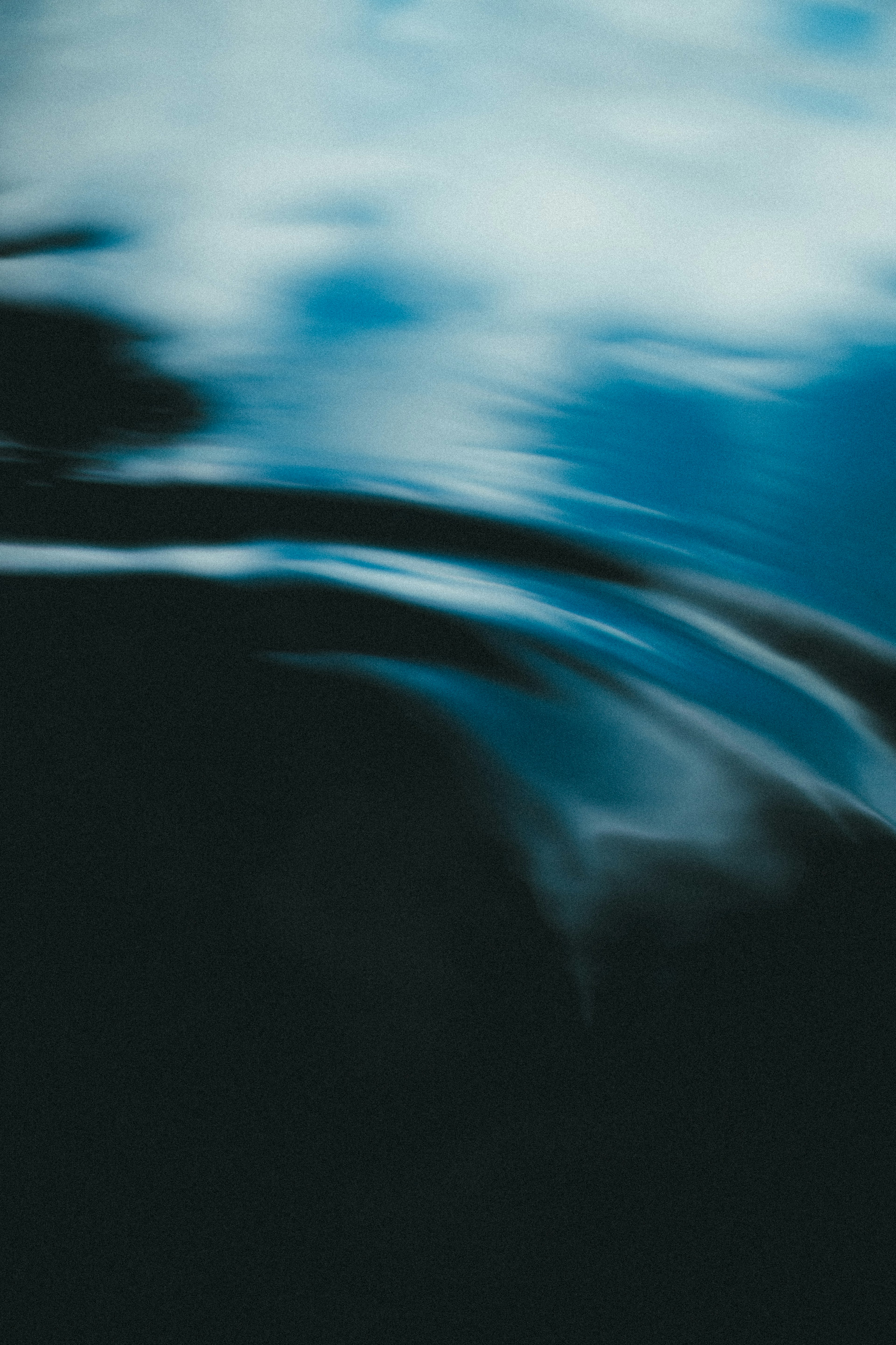 Abstract image of rippling water surface reflecting blue sky