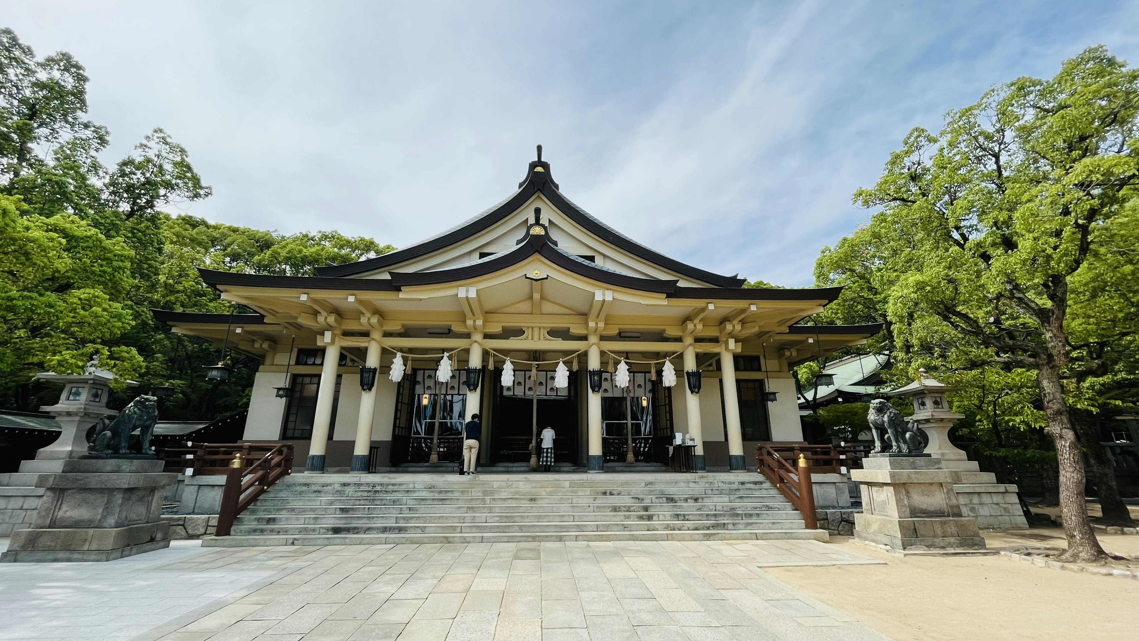 美麗的傳統日本神社外觀，四周環繞著綠樹