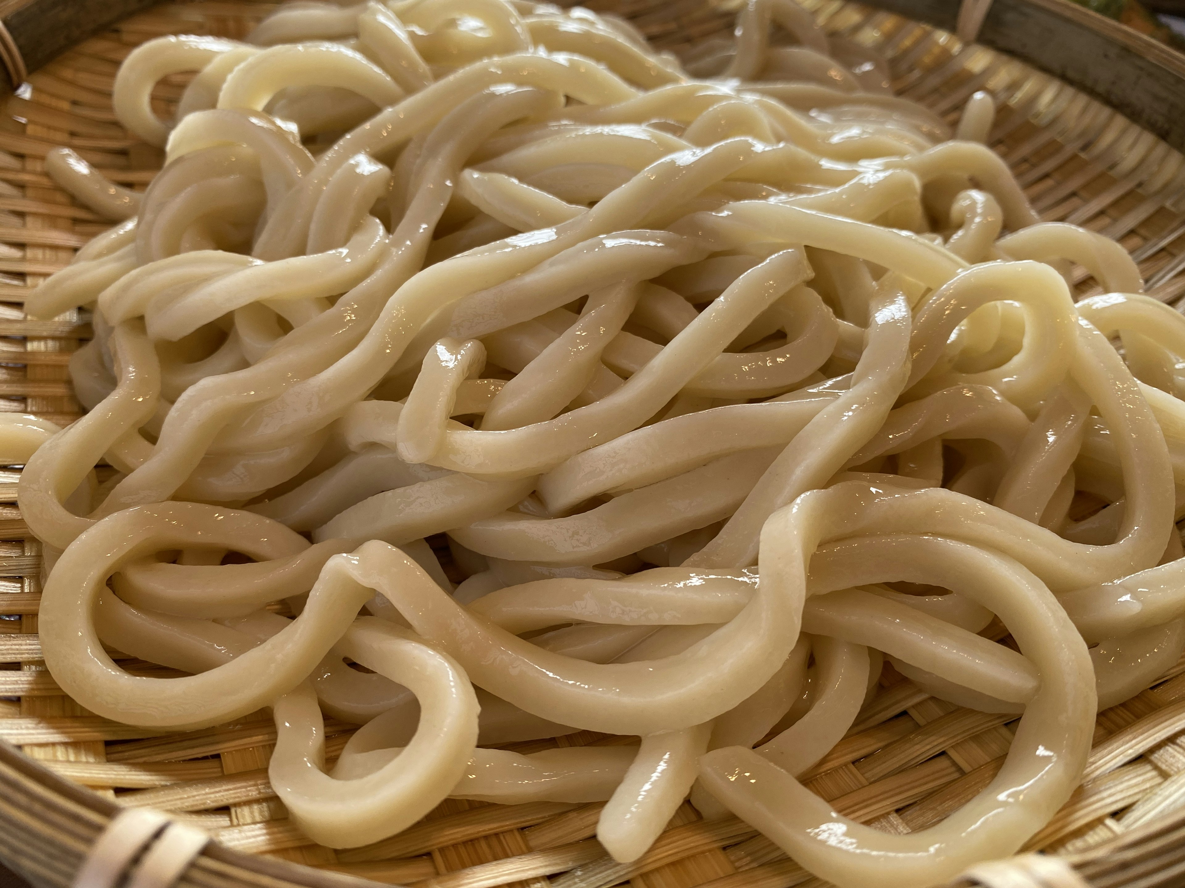 White udon noodles arranged in a bamboo basket