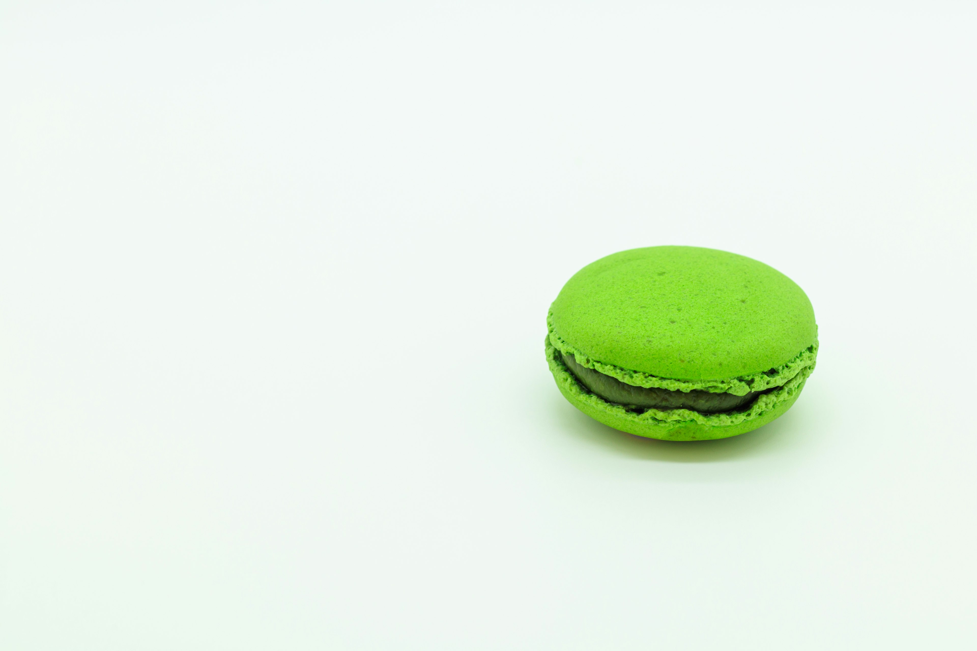 A green macaron placed on a white background