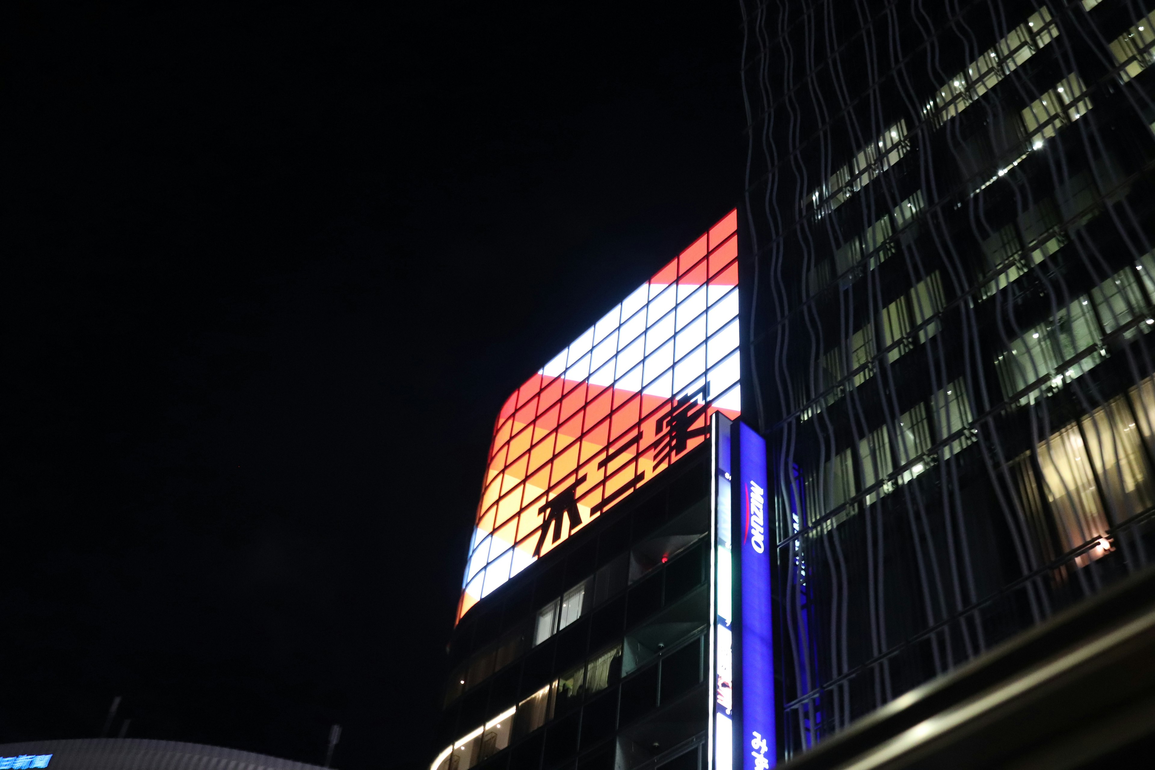 Cartel de edificio colorido iluminado por la noche en un entorno urbano