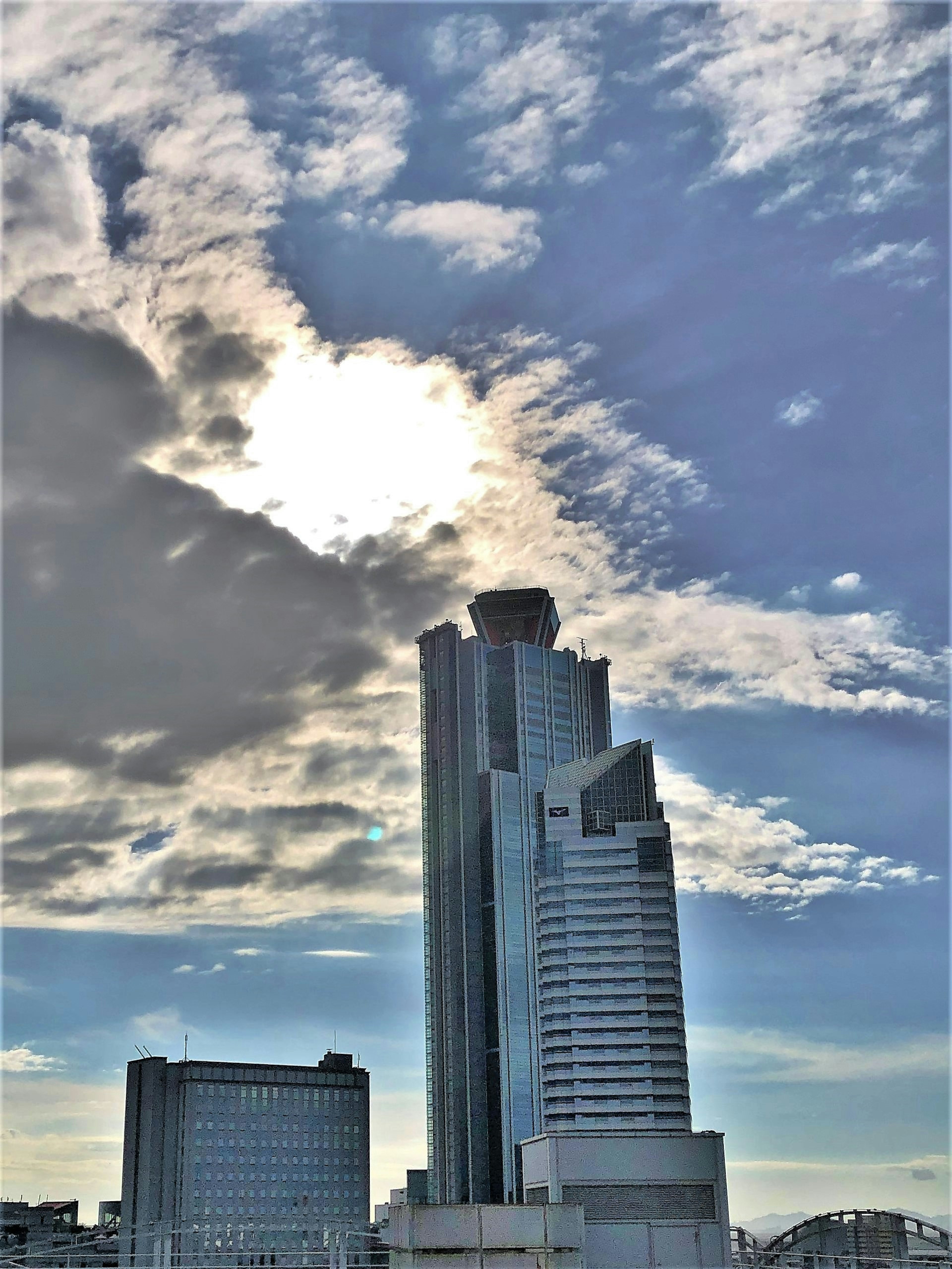 Skyline mit einem hohen Gebäude unter einem teilweise bewölkten Himmel