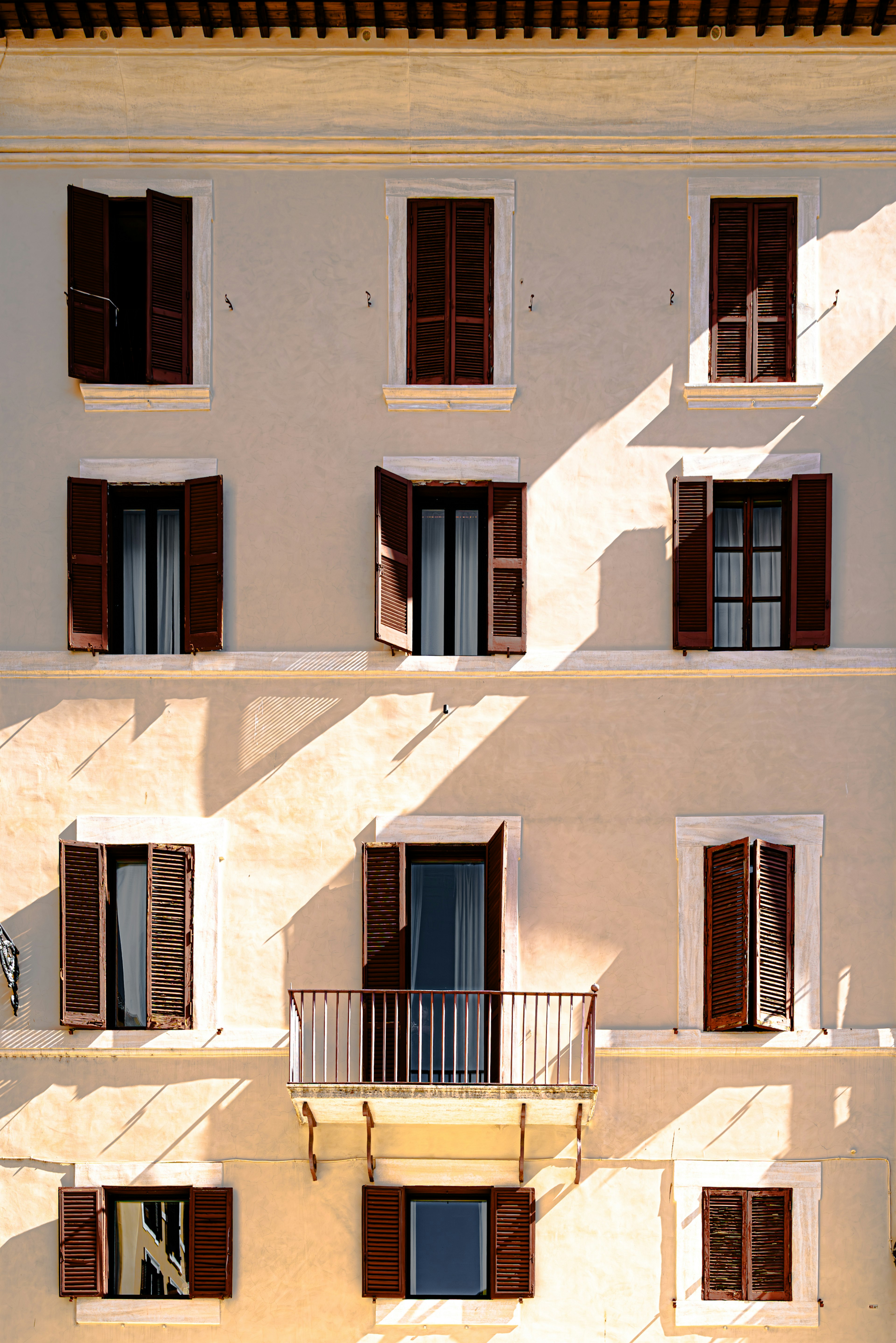 Edificio de paredes blancas ventanas y persianas marrones