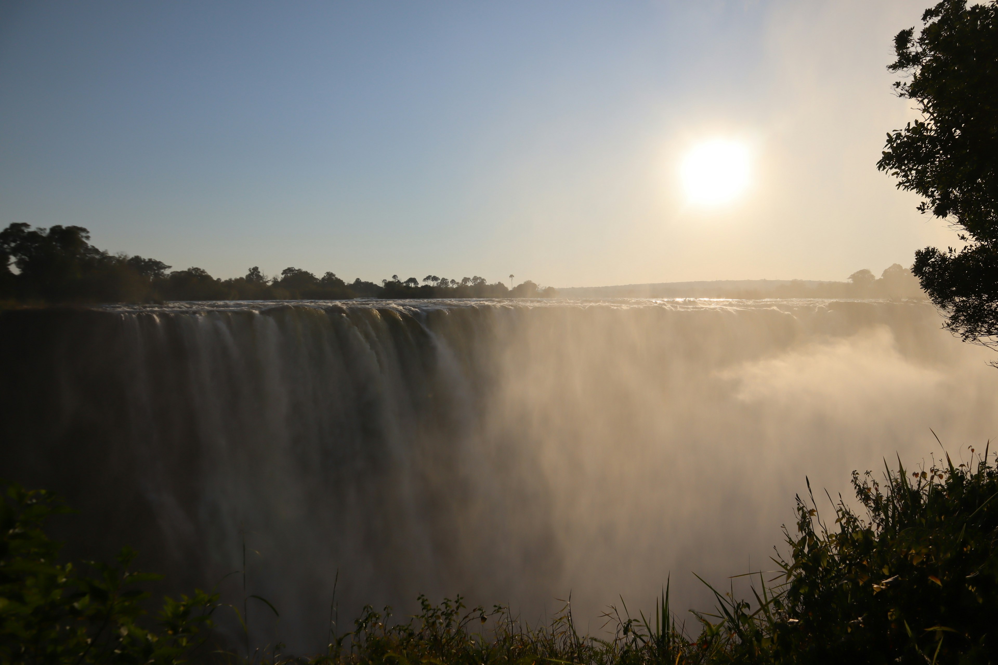 Vue magnifique d'une cascade avec la silhouette du soleil en arrière-plan