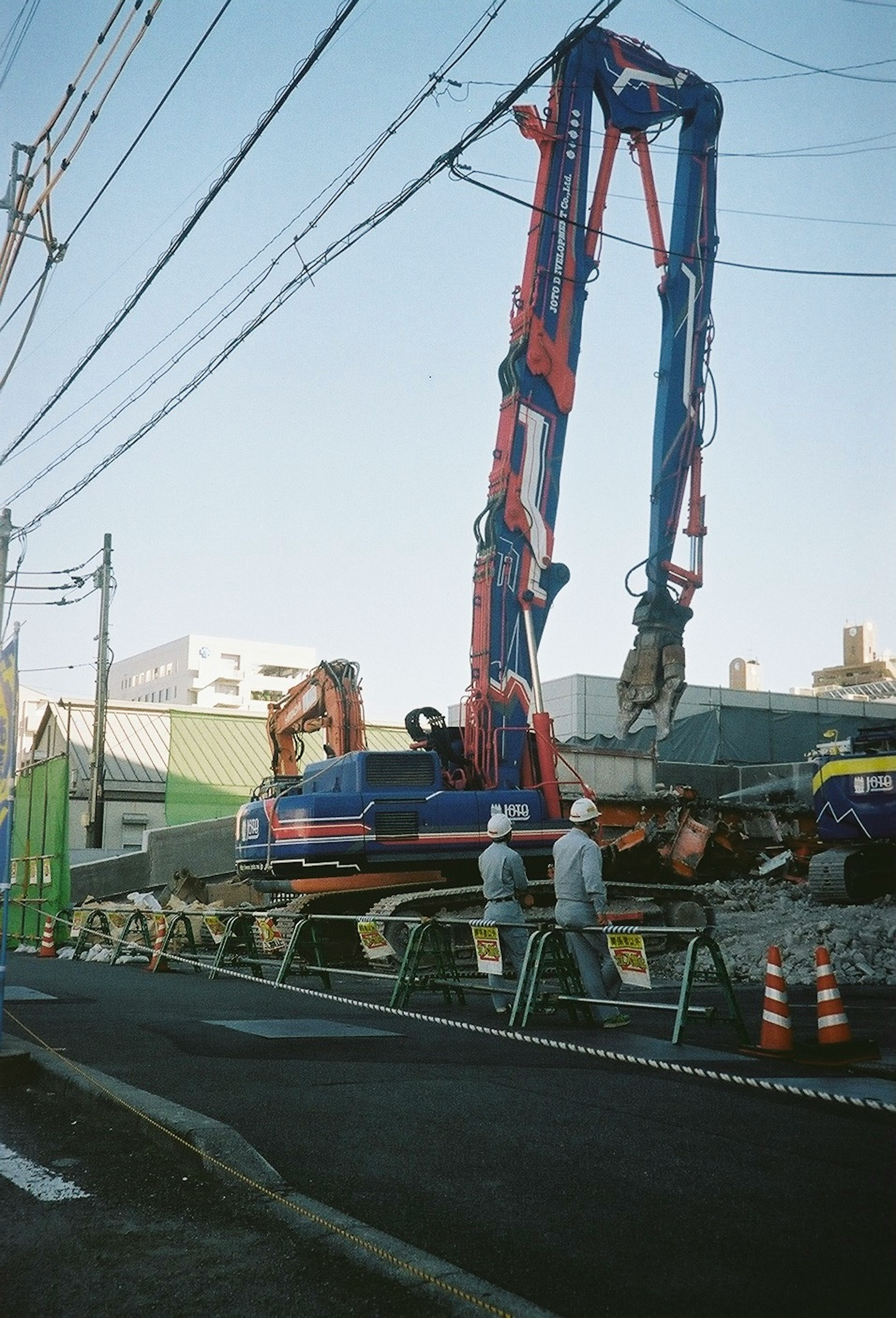 道路工事中のクレーンと作業員の画像