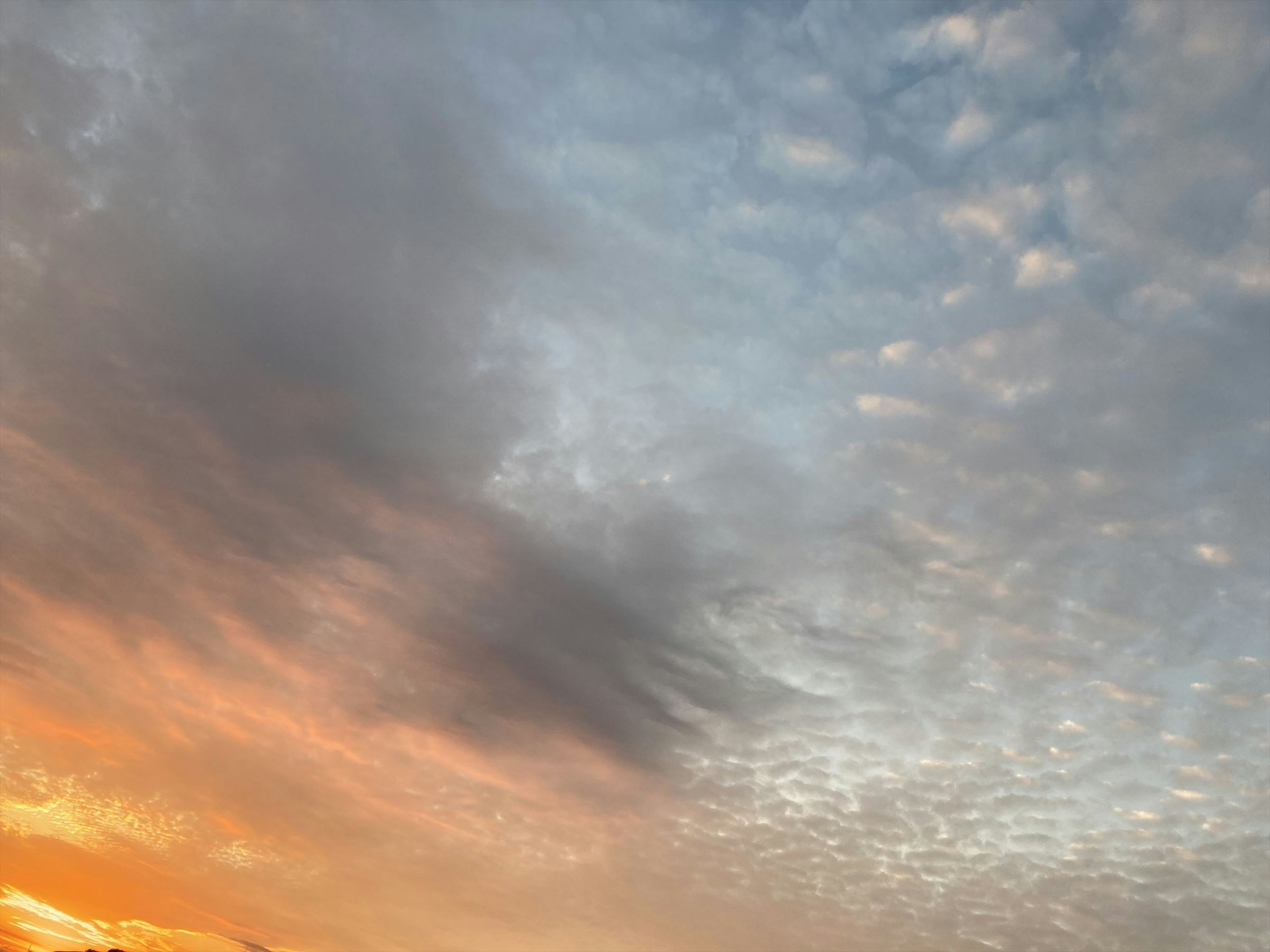 Hermoso contraste entre el atardecer naranja y las nubes del cielo azul