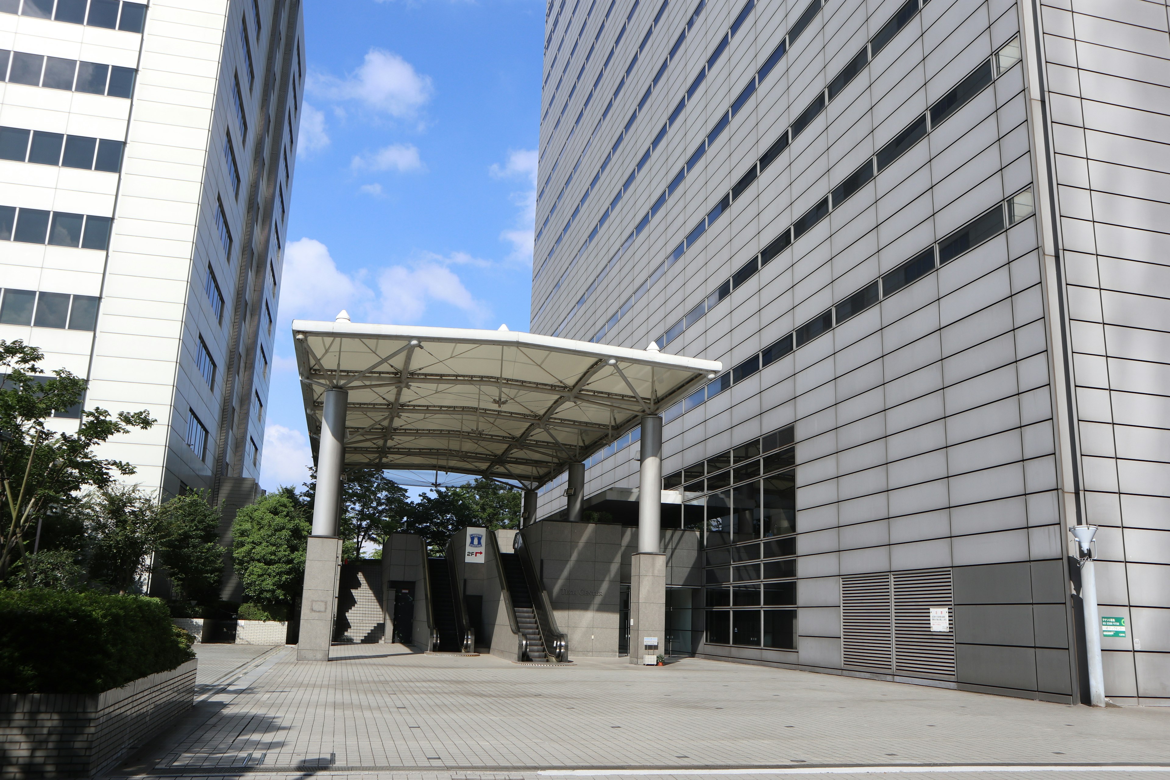 Image d'une entrée de bâtiment moderne avec un large trottoir