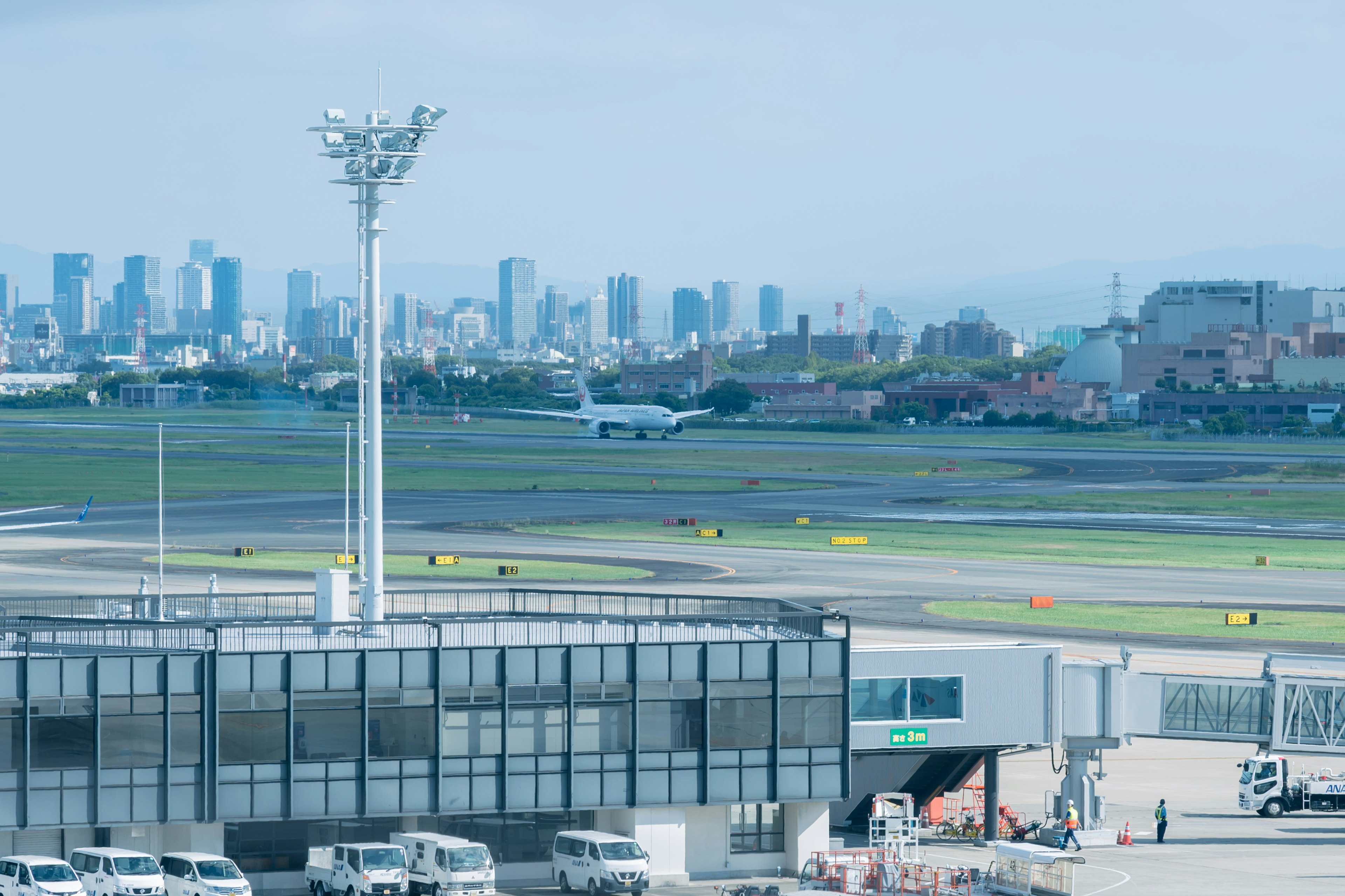 Airport terminal and runway view with city skyscrapers in the background