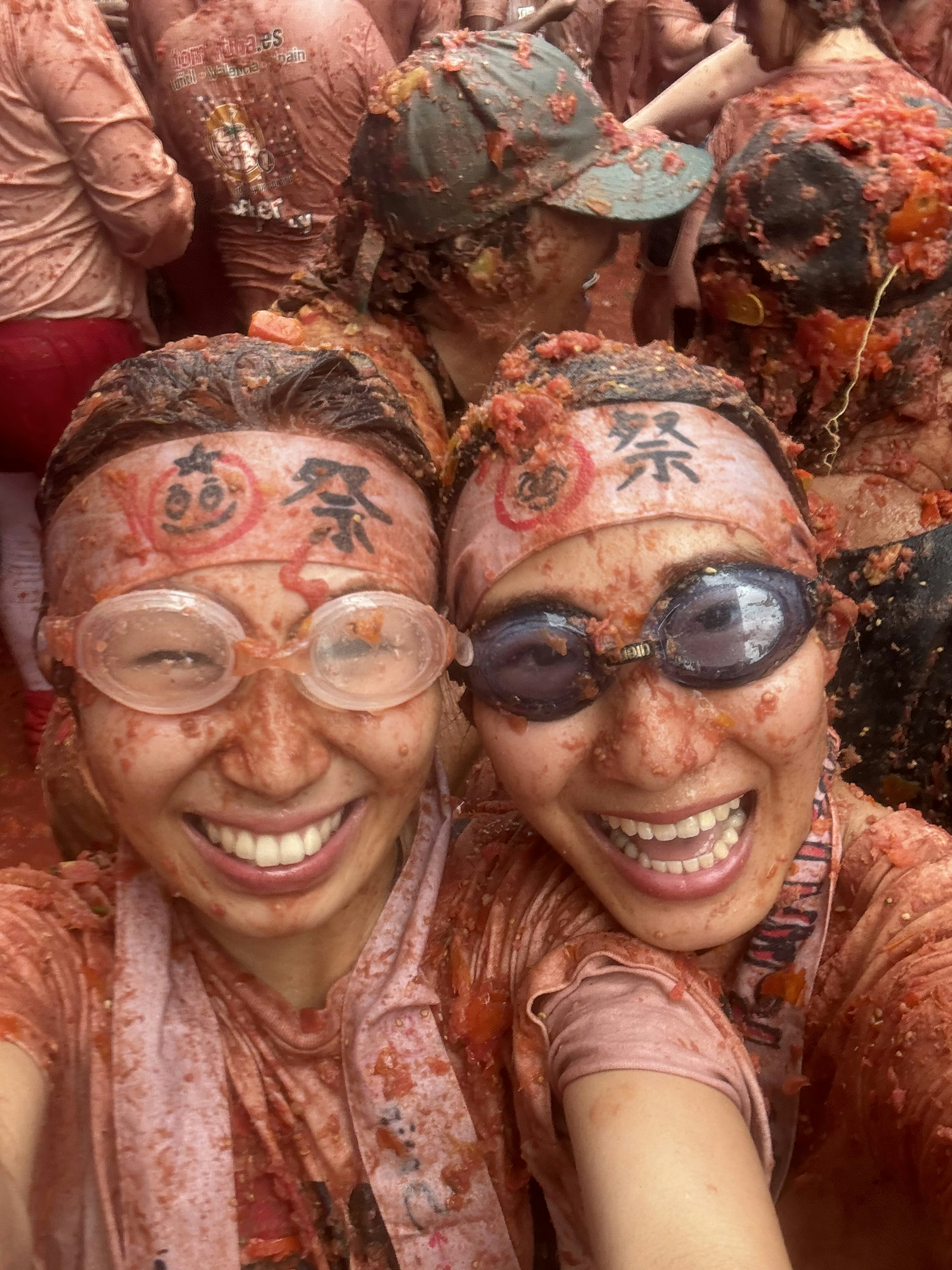 Zwei Frauen, die mit Tomaten bedeckt sind und für ein Selfie lächeln