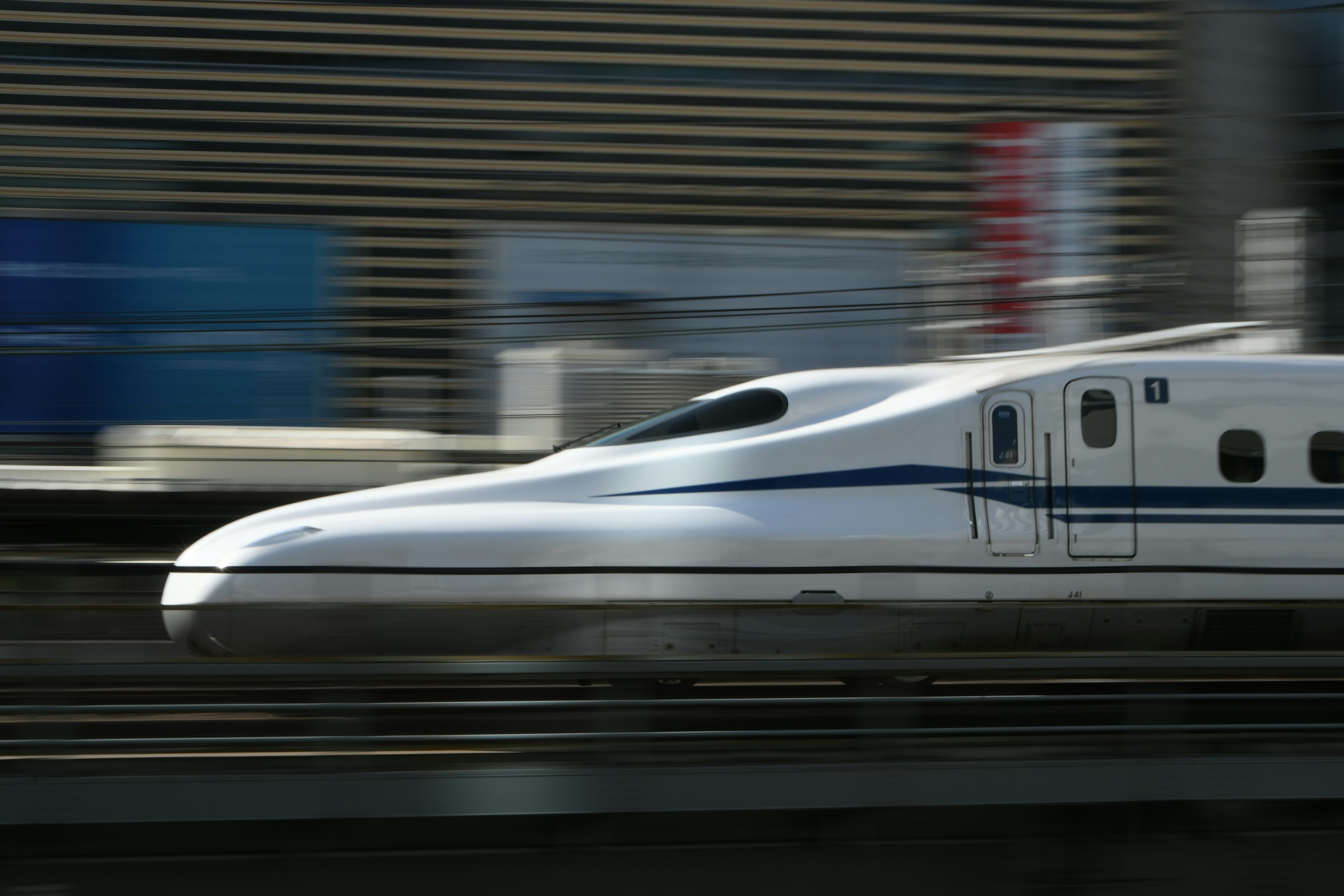 Shinkansen train speeding past on tracks