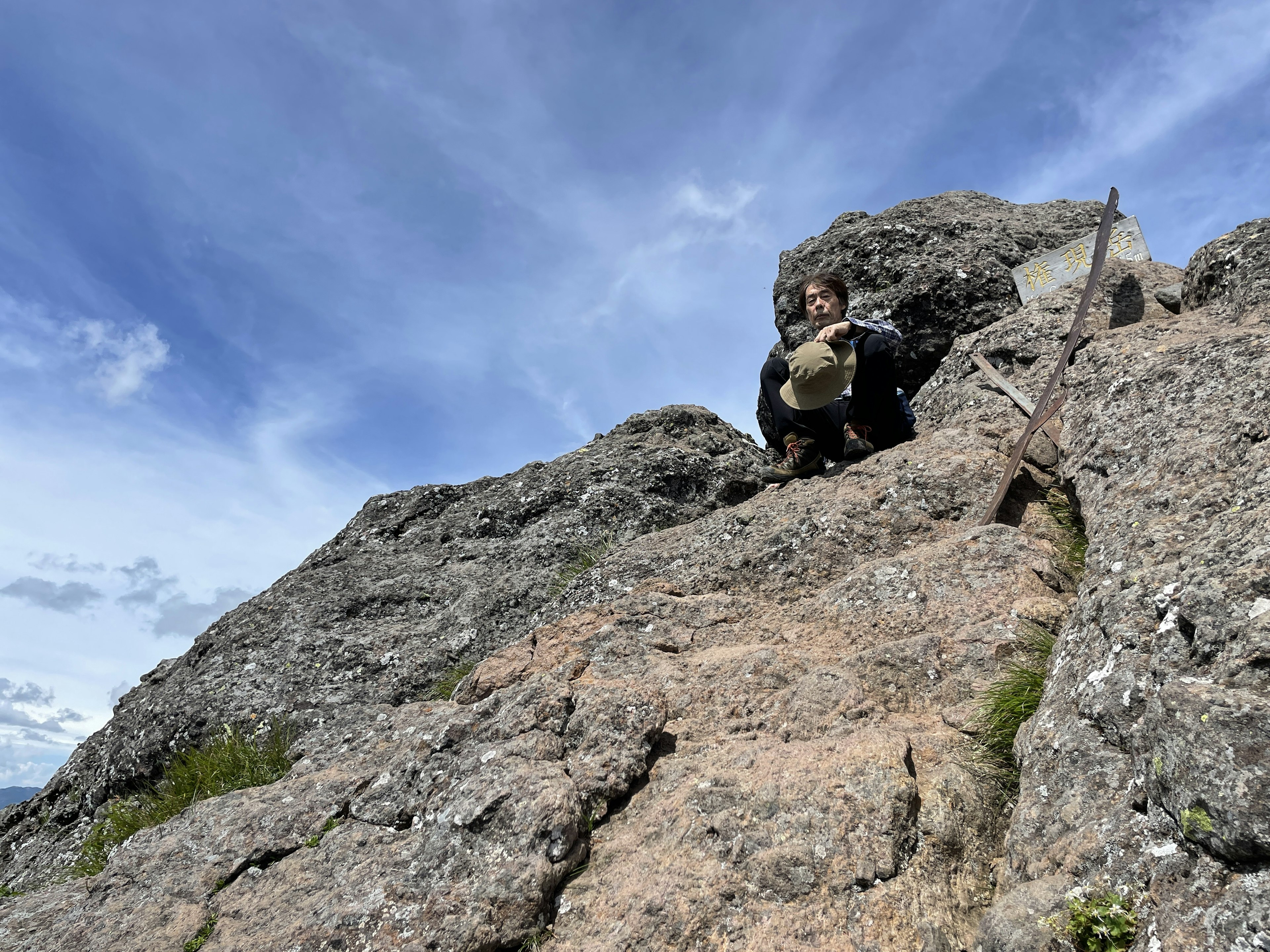 Persona che scala una montagna rocciosa con cielo blu