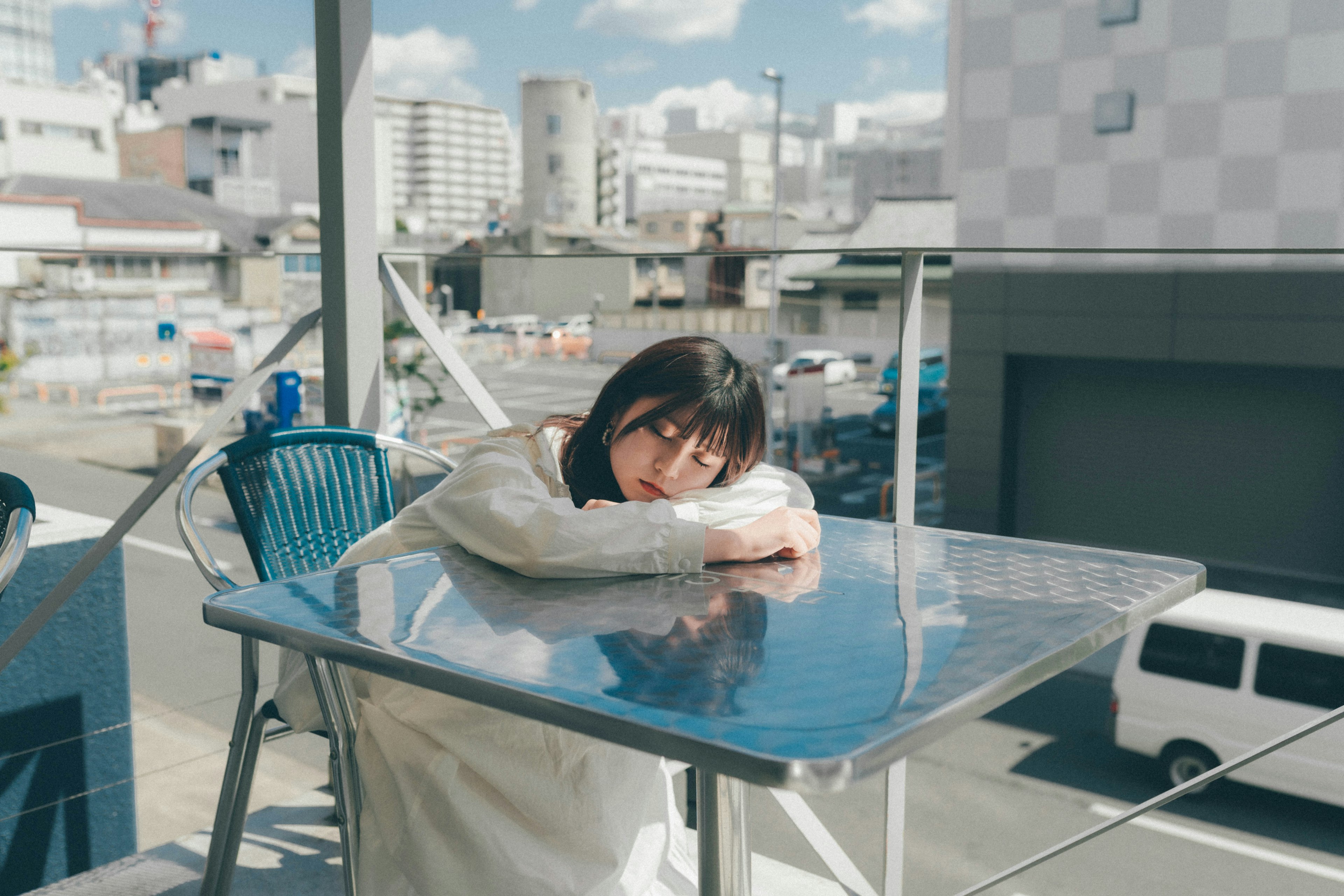 カフェのテラスでテーブルに寄りかかる女性のポートレート