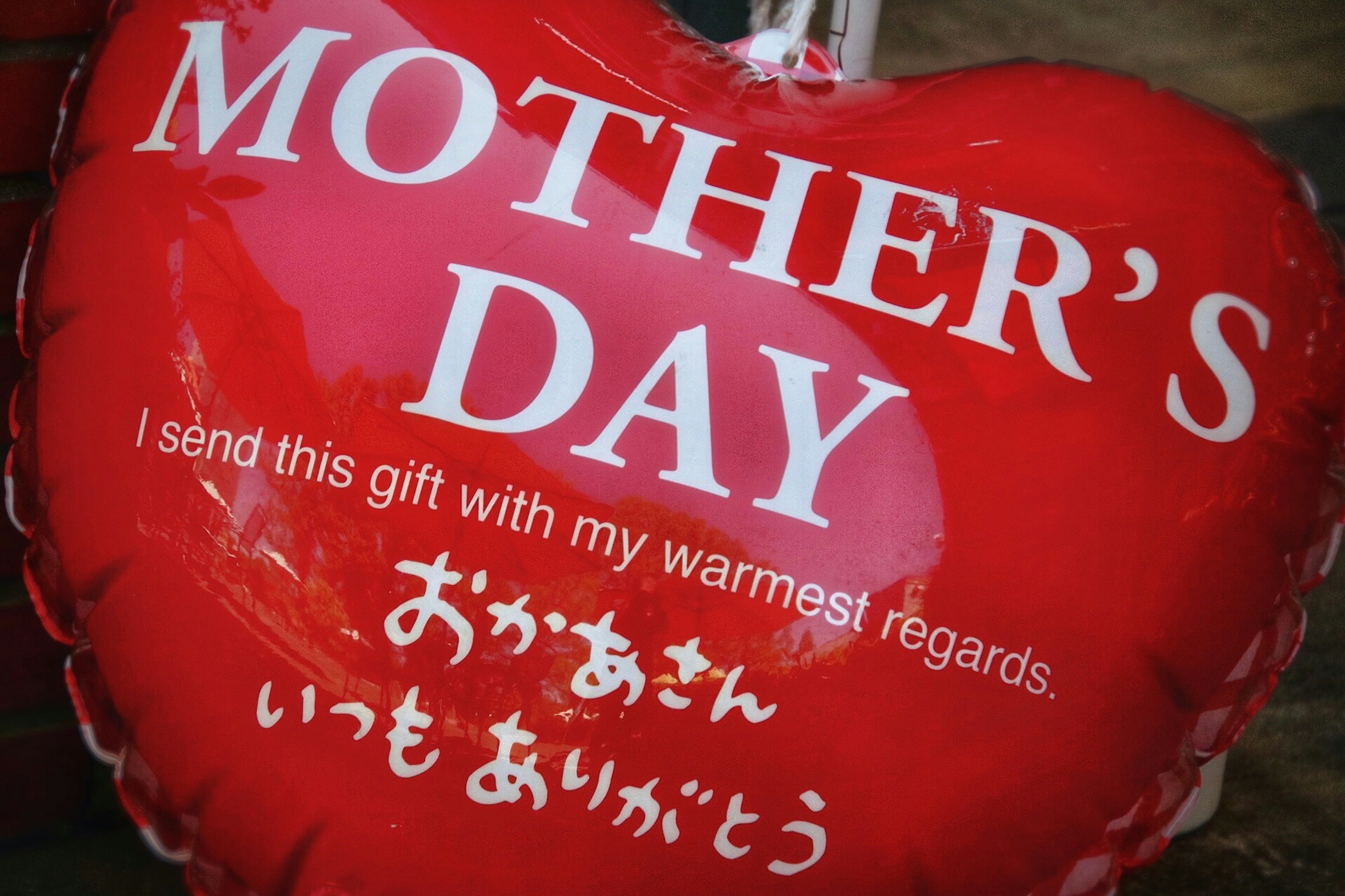 Ballon en forme de cœur rouge avec l'inscription de la fête des mères et des vœux chaleureux