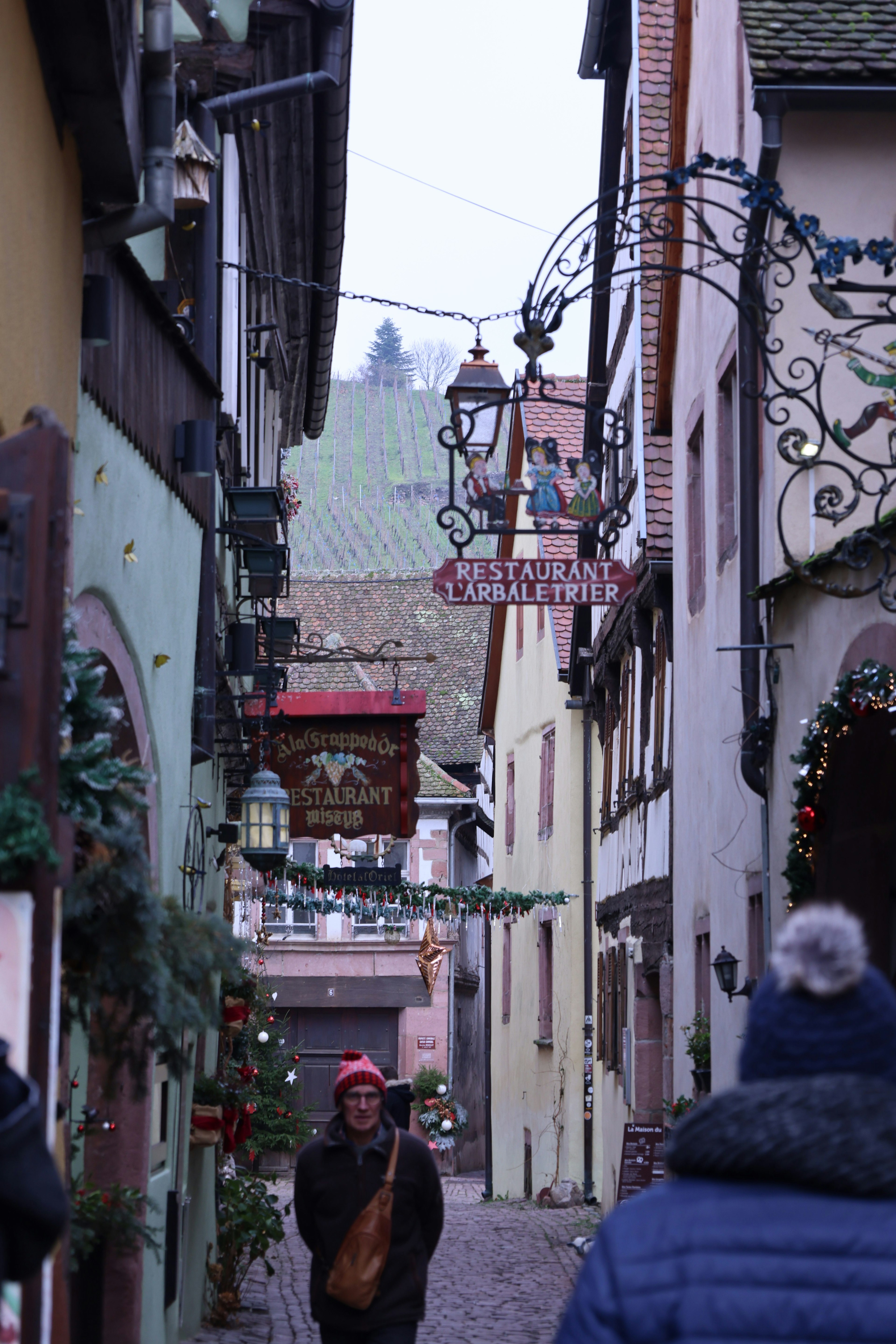 Rue étroite en hiver avec une personne et des bâtiments décorés