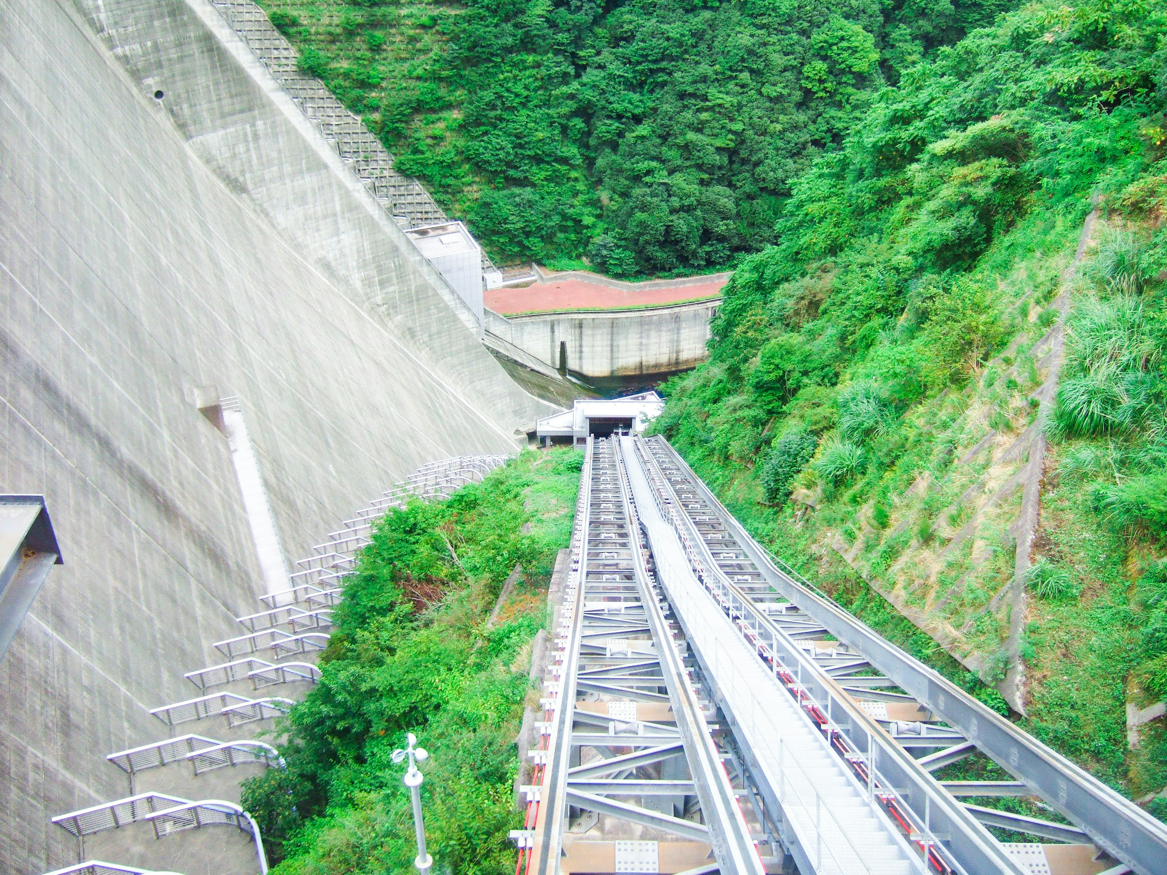 Cable car track ascending through lush green mountains