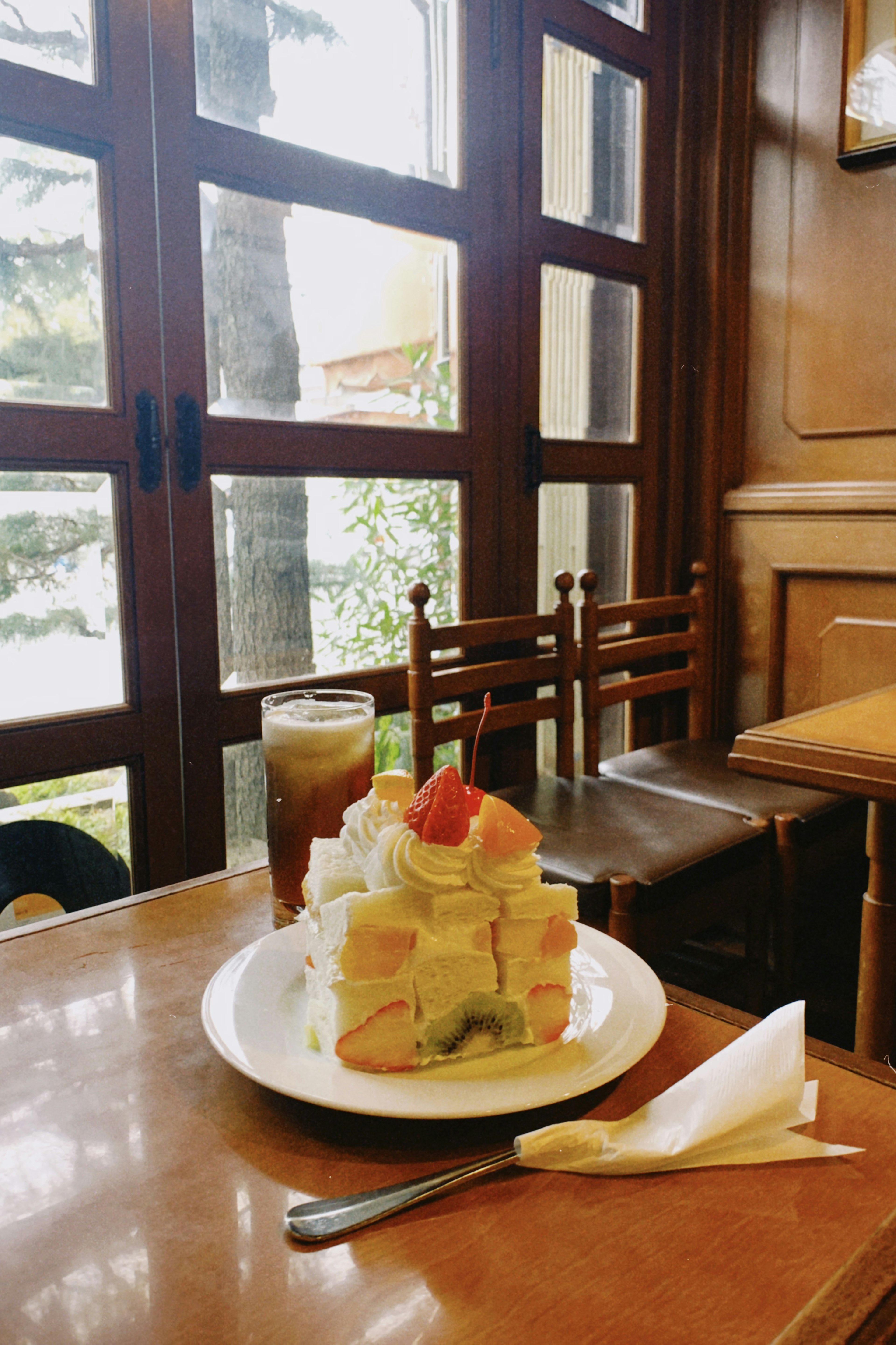 Ein Foto von einer Obsttorte und Eistee auf einem Cafétisch