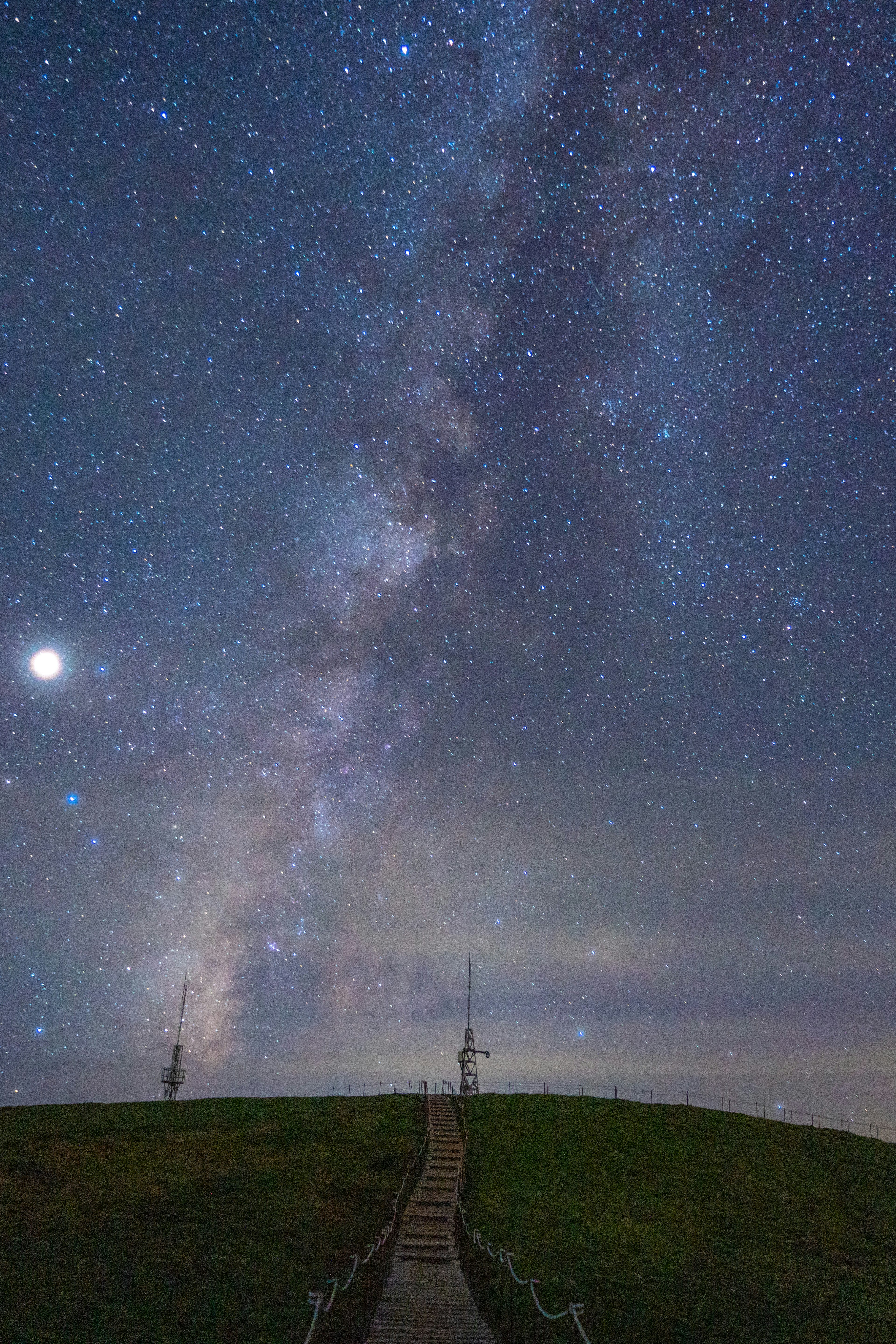 A pathway leading to the Milky Way under a starry sky