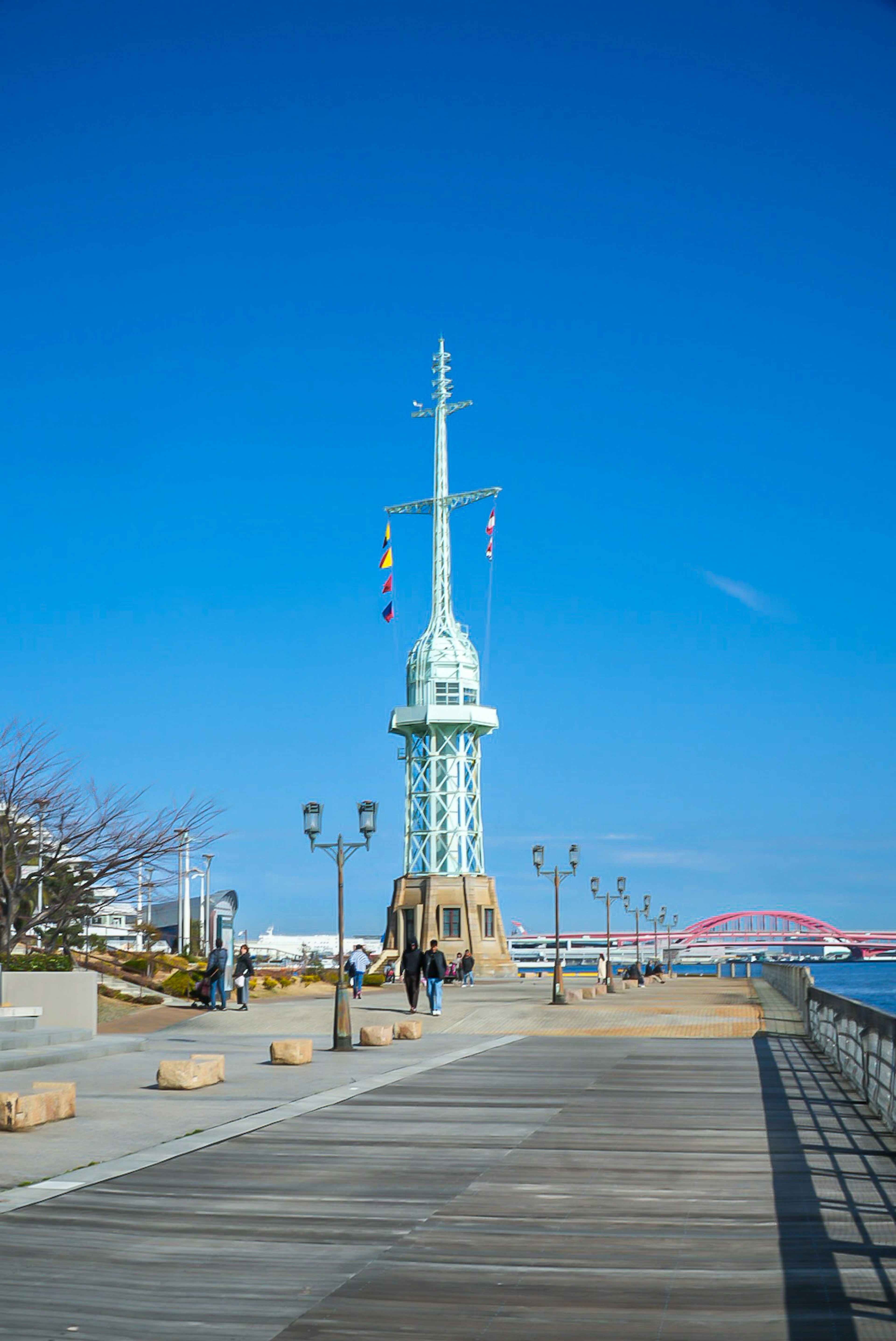 Vue pittoresque d'un phare sous un ciel bleu avec une promenade en bois