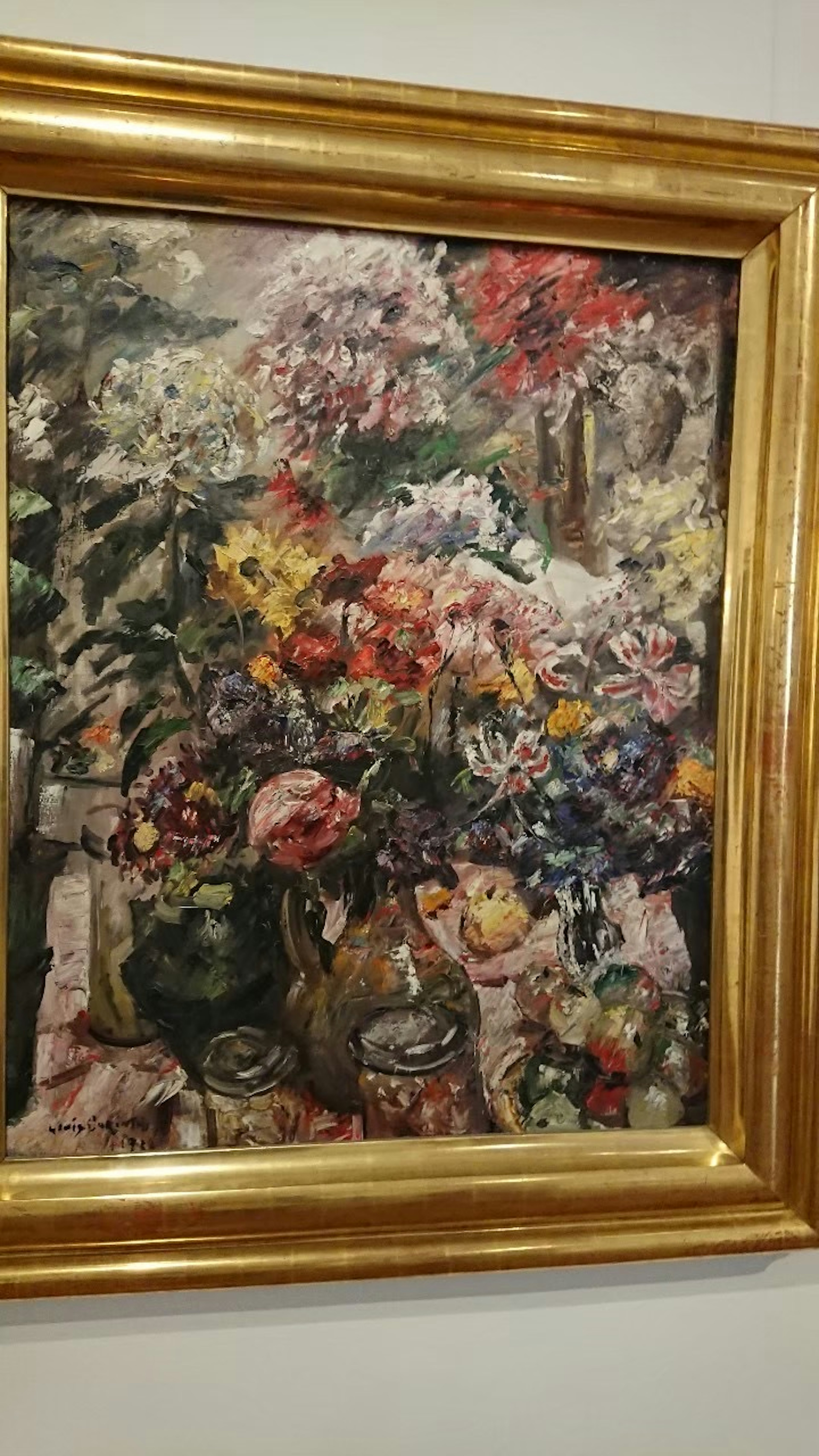 Une peinture de fleurs colorées entourée d'un cadre doré luxueux