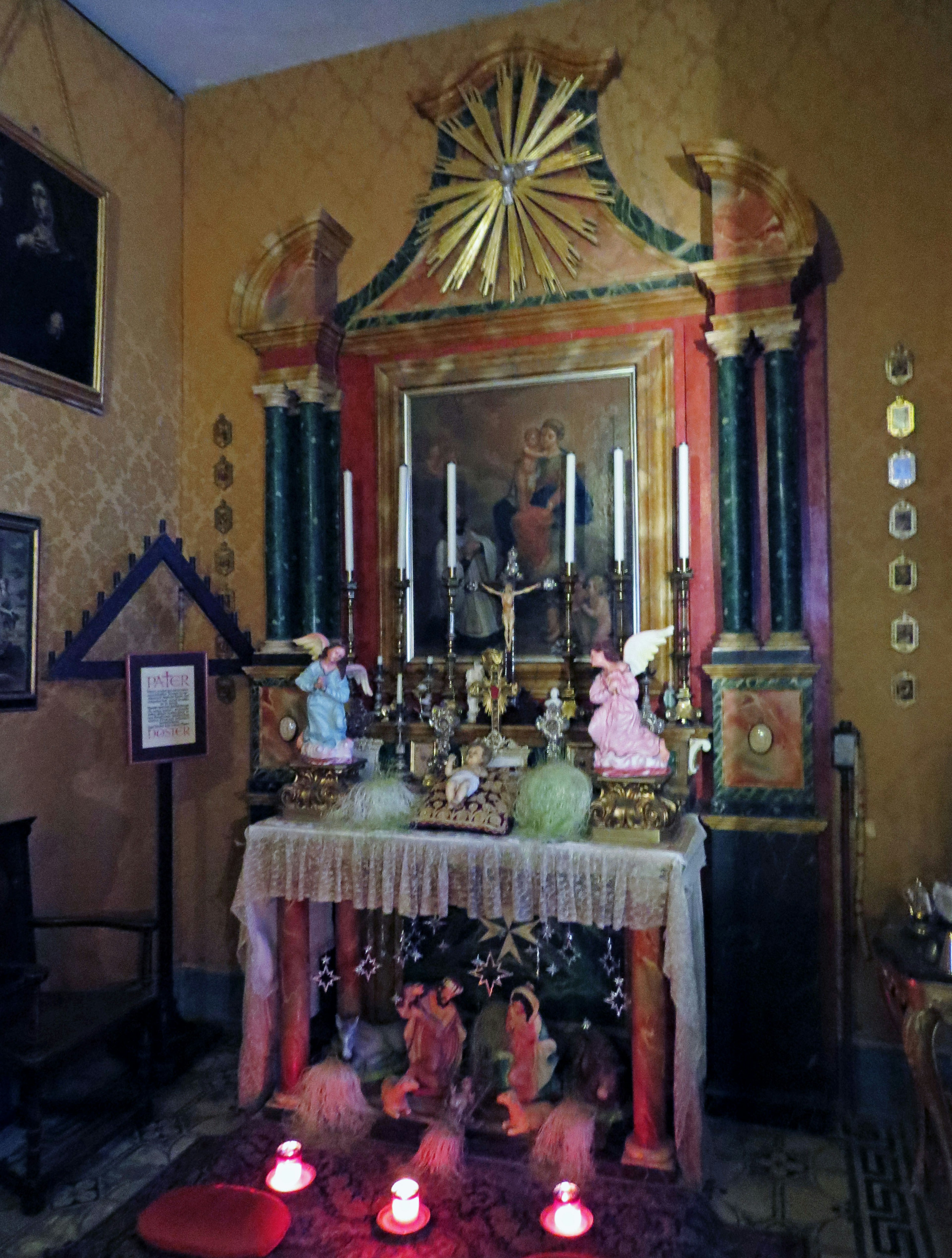 A decorated altar room featuring glowing candles and small statues