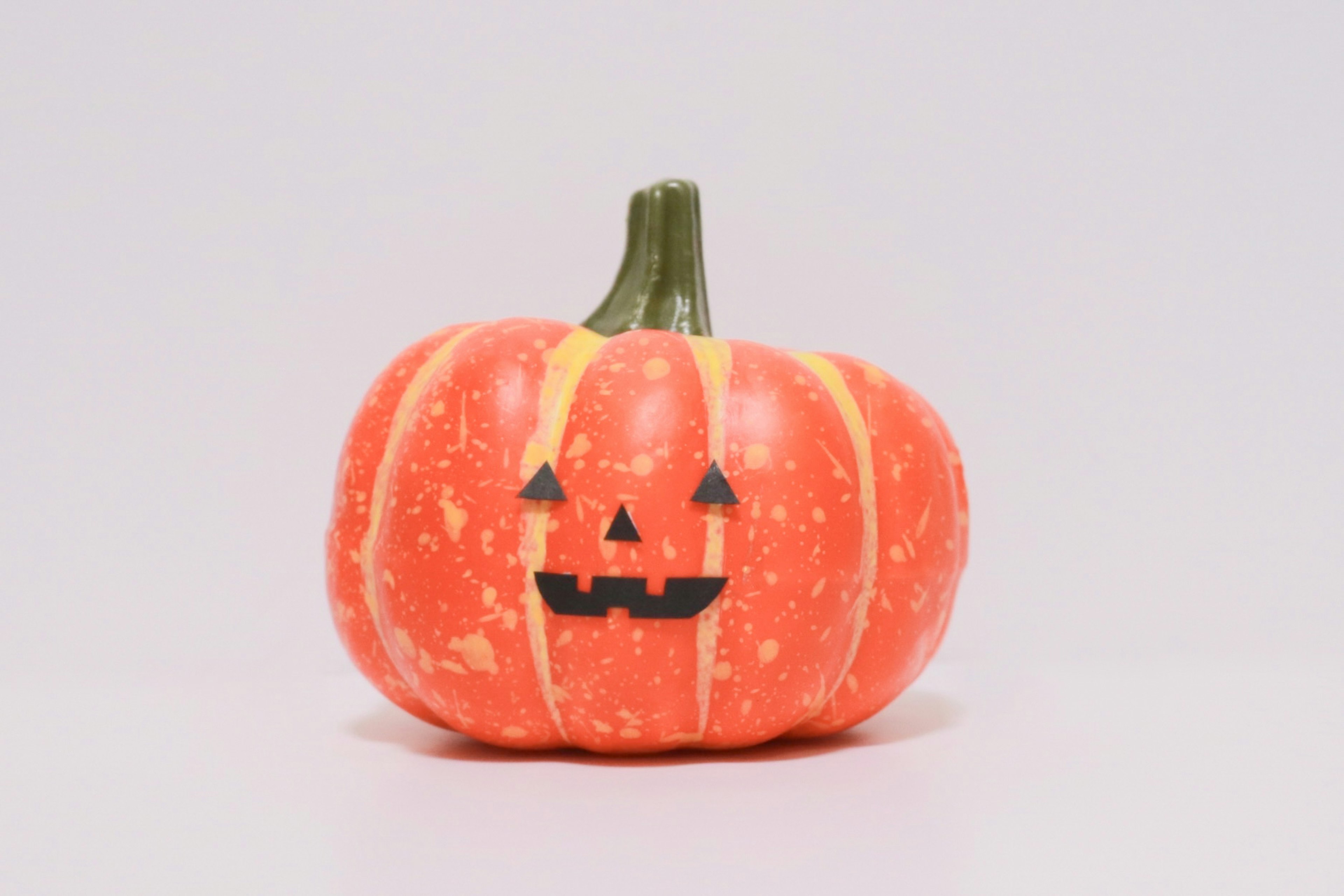 Zucca arancione con un volto di jack-o'-lantern intagliato