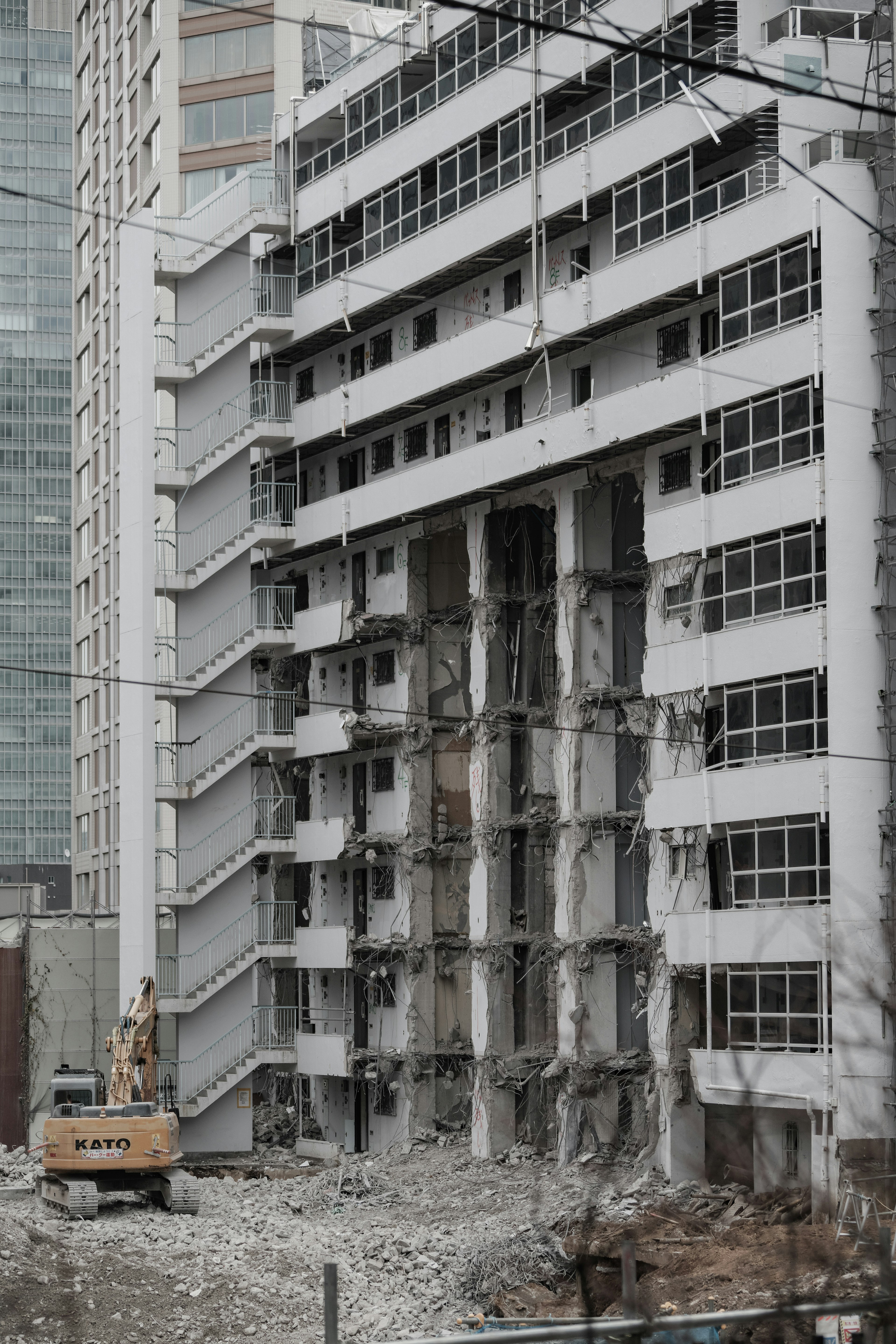 Exterior view of a building under demolition with surrounding debris