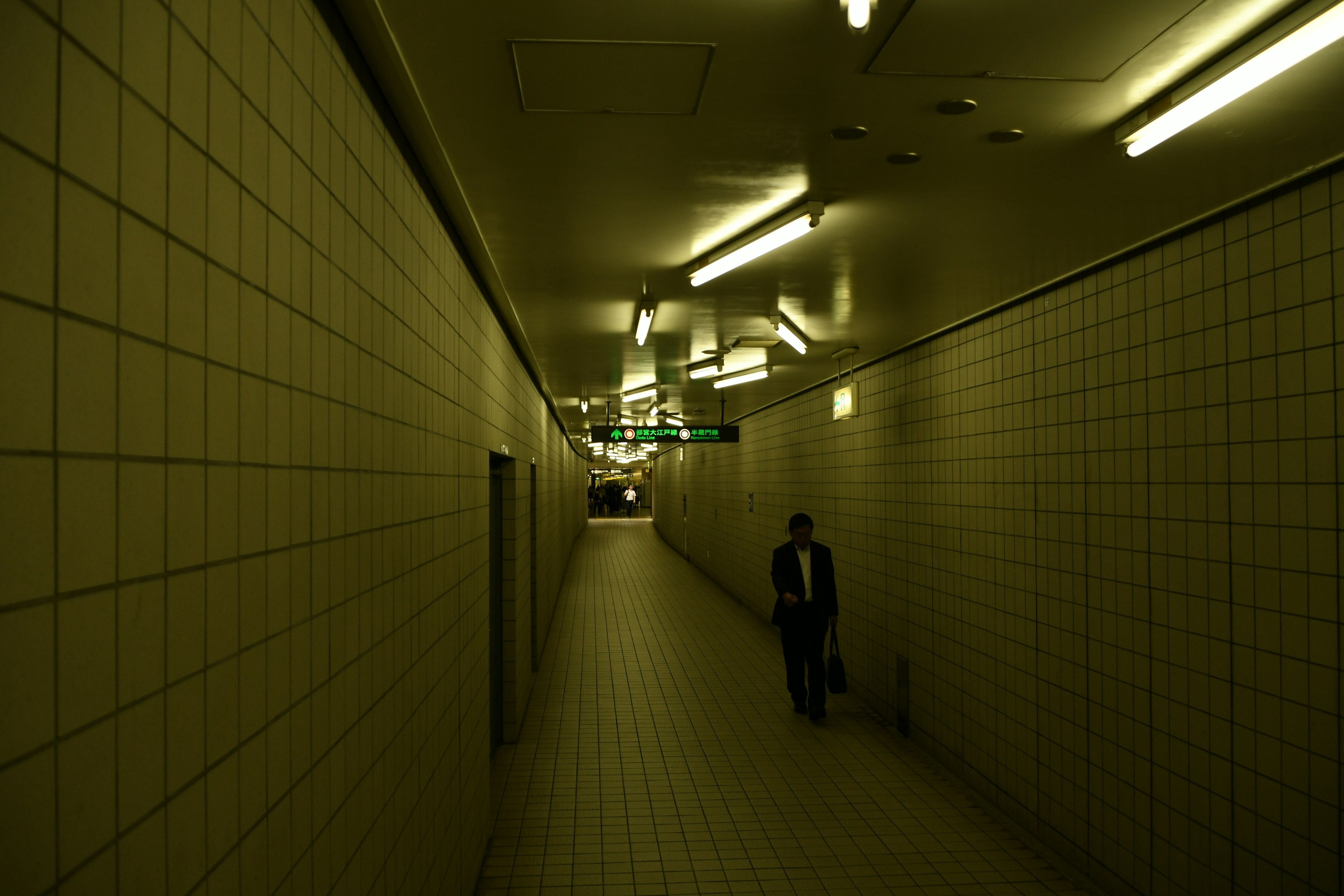 A man walking in a dimly lit underground passageway