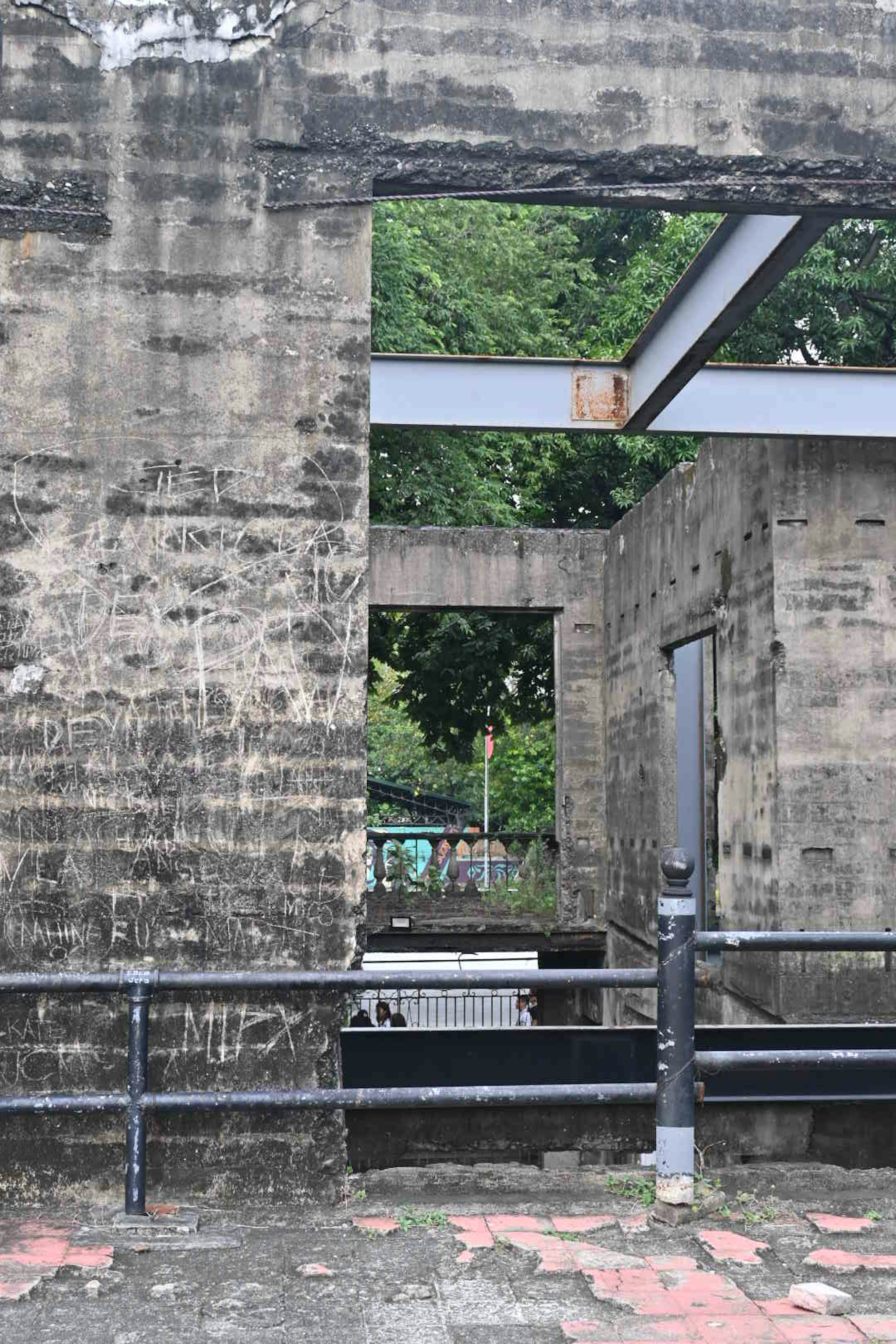 Abandoned structure with concrete walls and metal beams visible