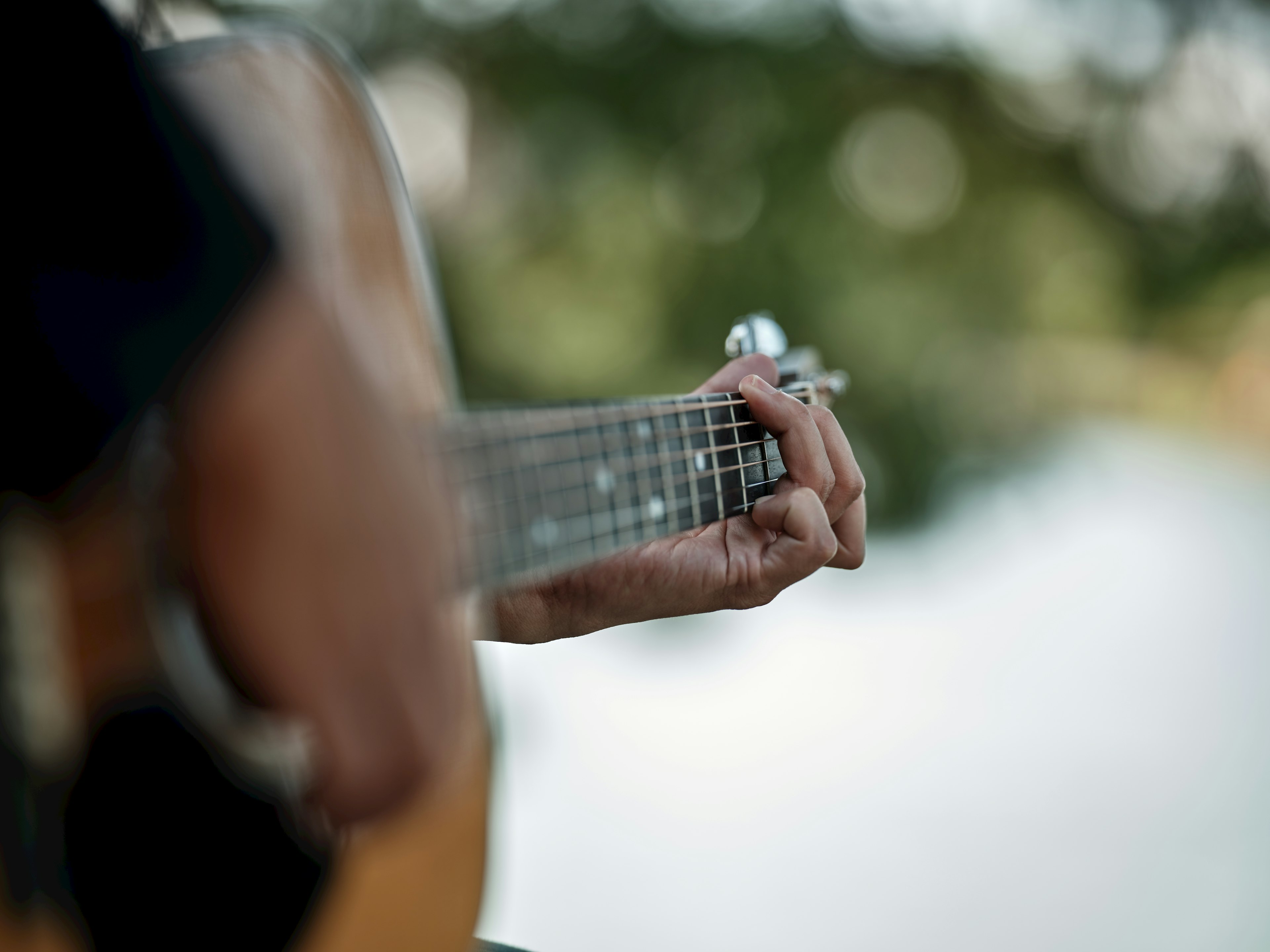 Primer plano de manos tocando una guitarra acústica