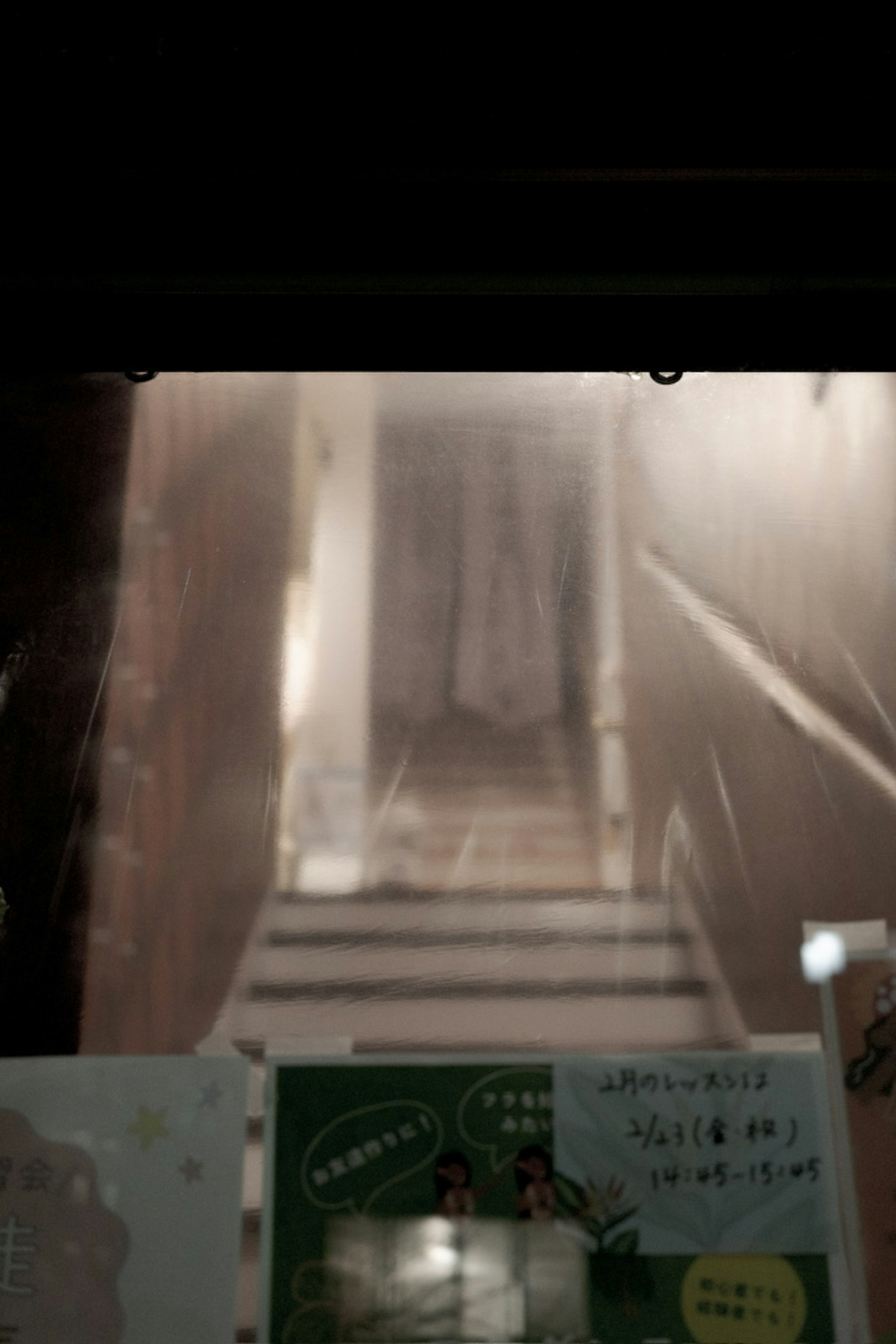 A photo showing a dimly lit staircase leading to a door with a misty effect