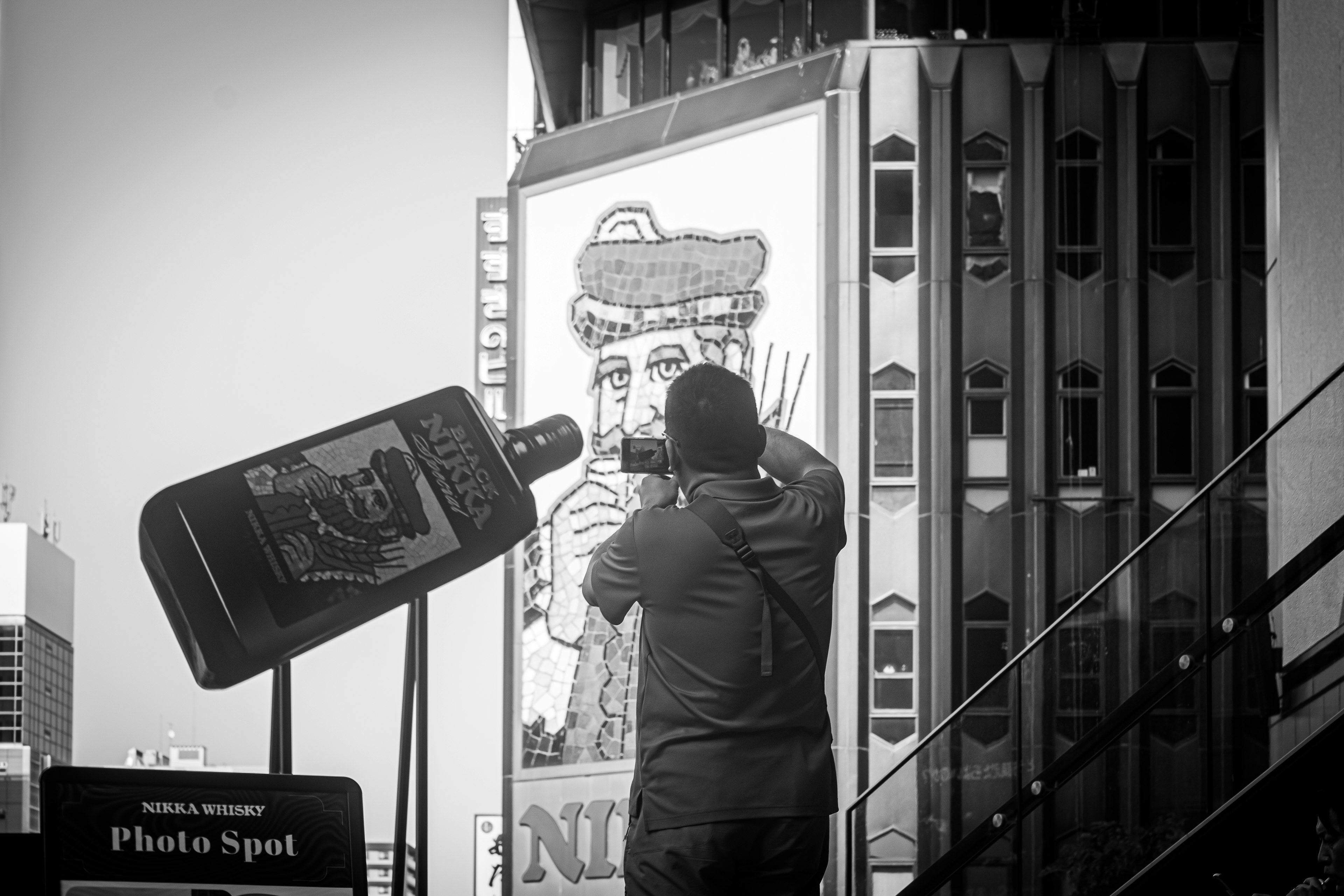 Una persona tomando una foto de un gran mural en un edificio