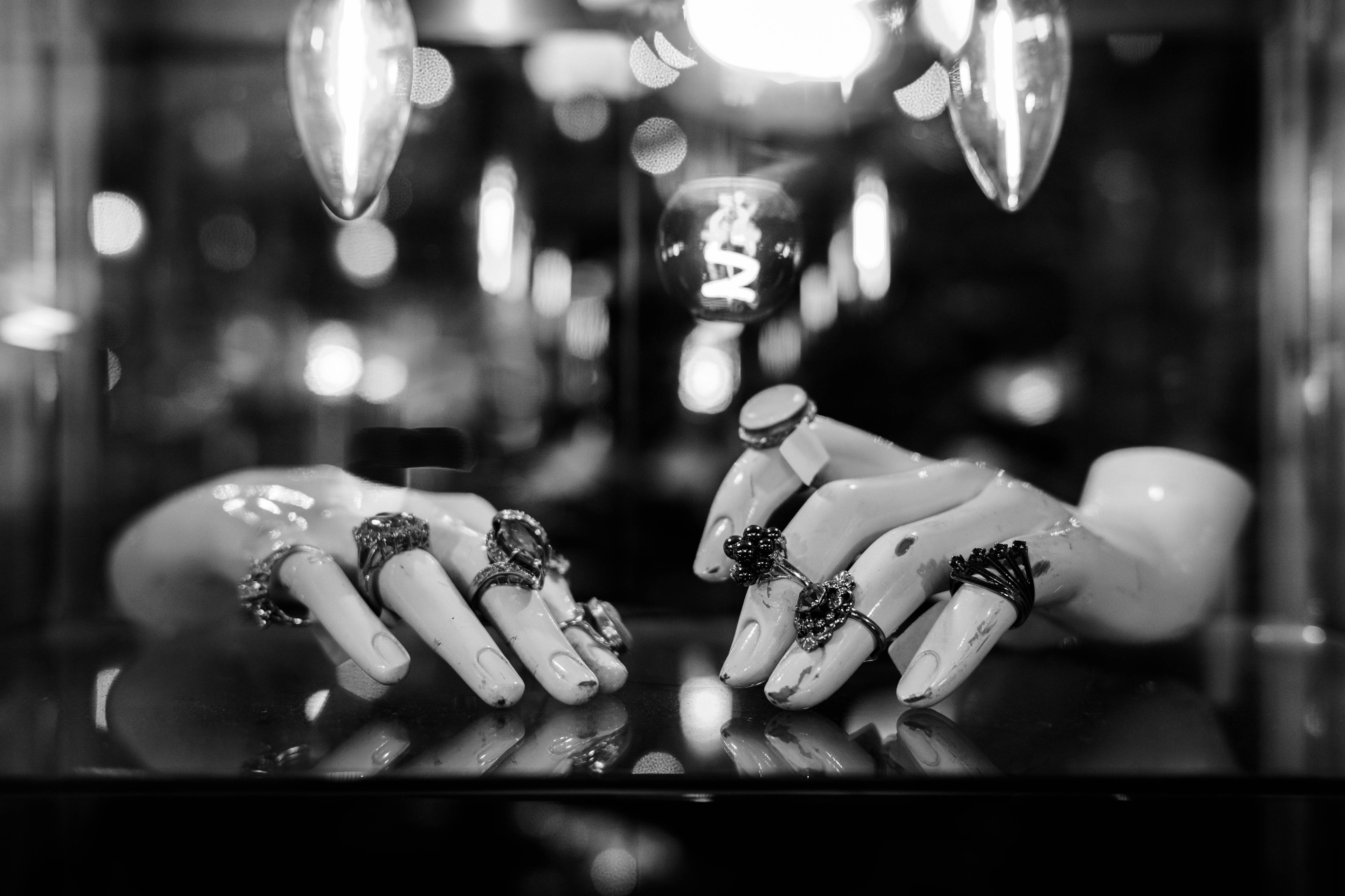 Monochrome photo of decorative ring-adorned hand models displayed