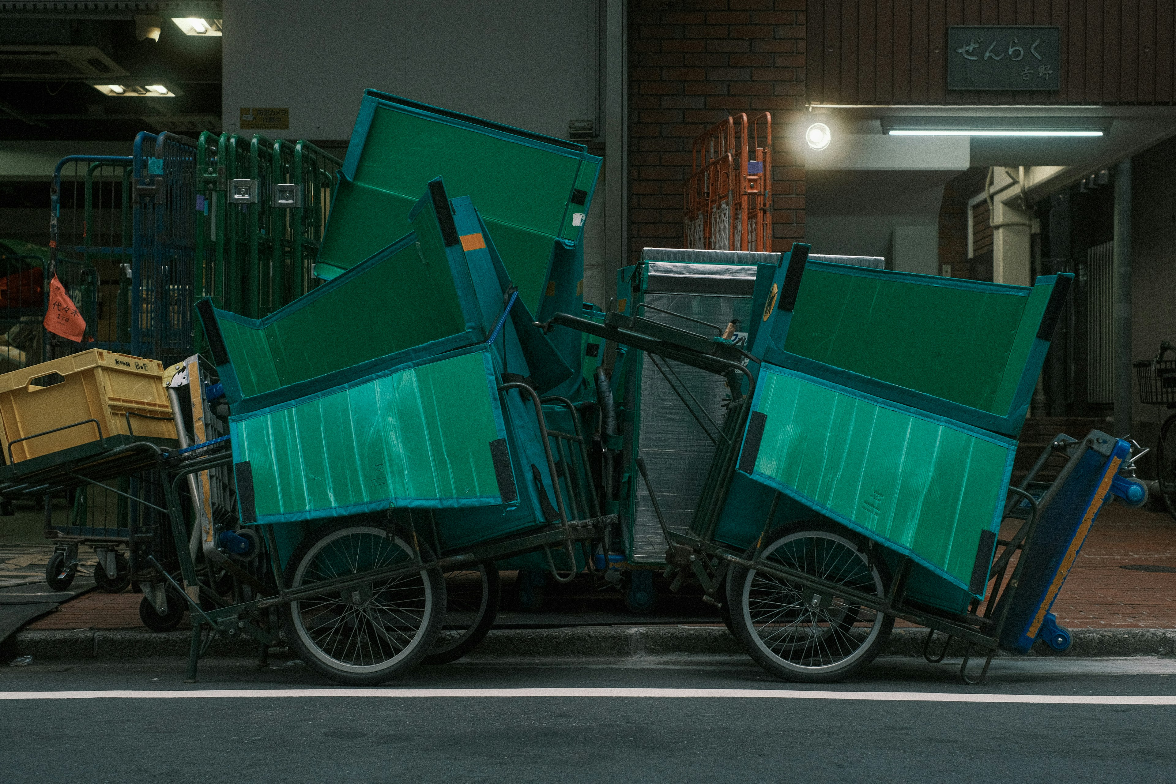 Deux chariots à ordures verts empilés dans une rue