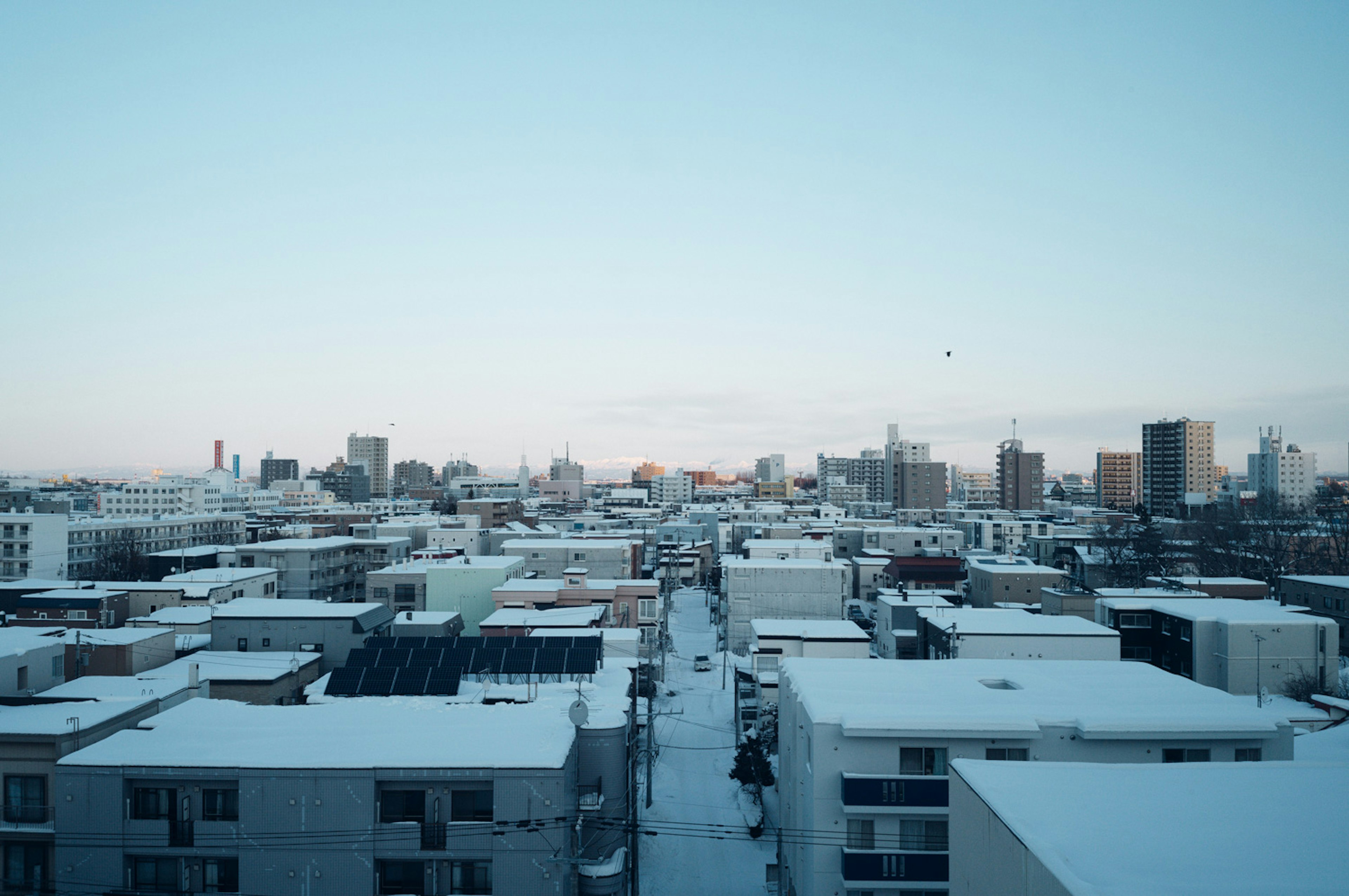 Paisaje urbano cubierto de nieve con cielo azul claro