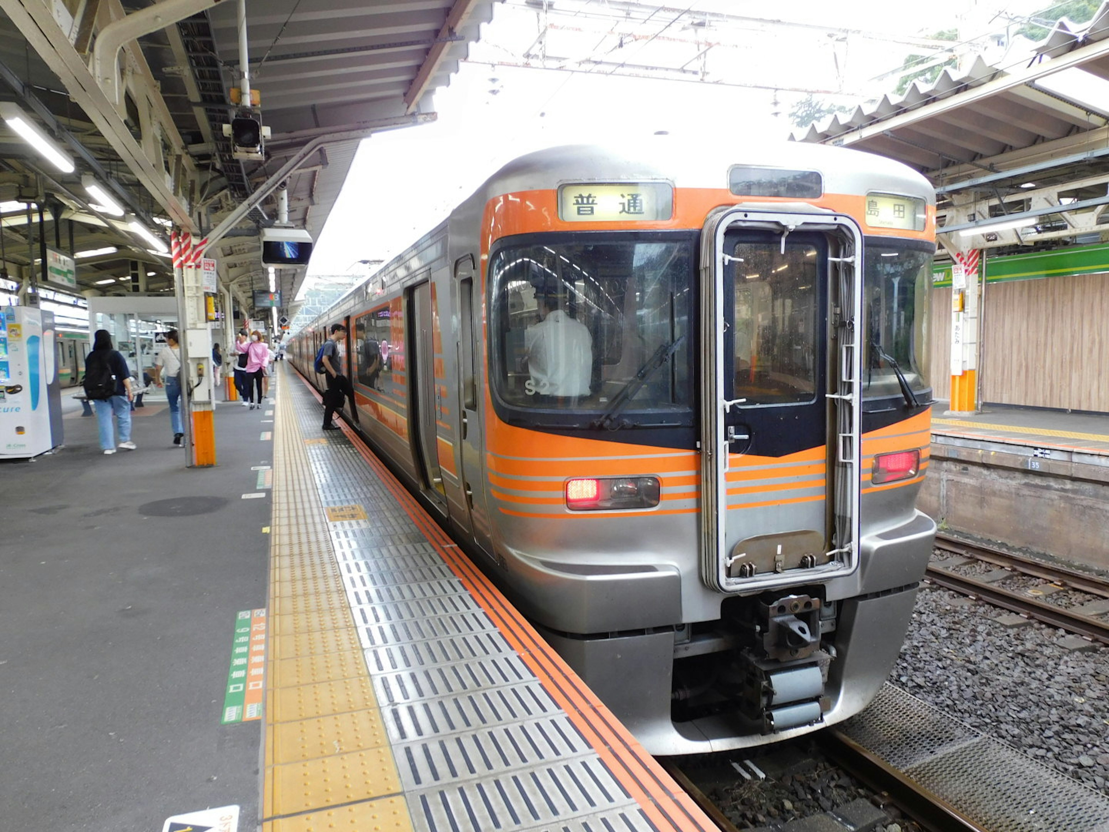 รถไฟสีส้มและสีเงินจอดที่สถานี