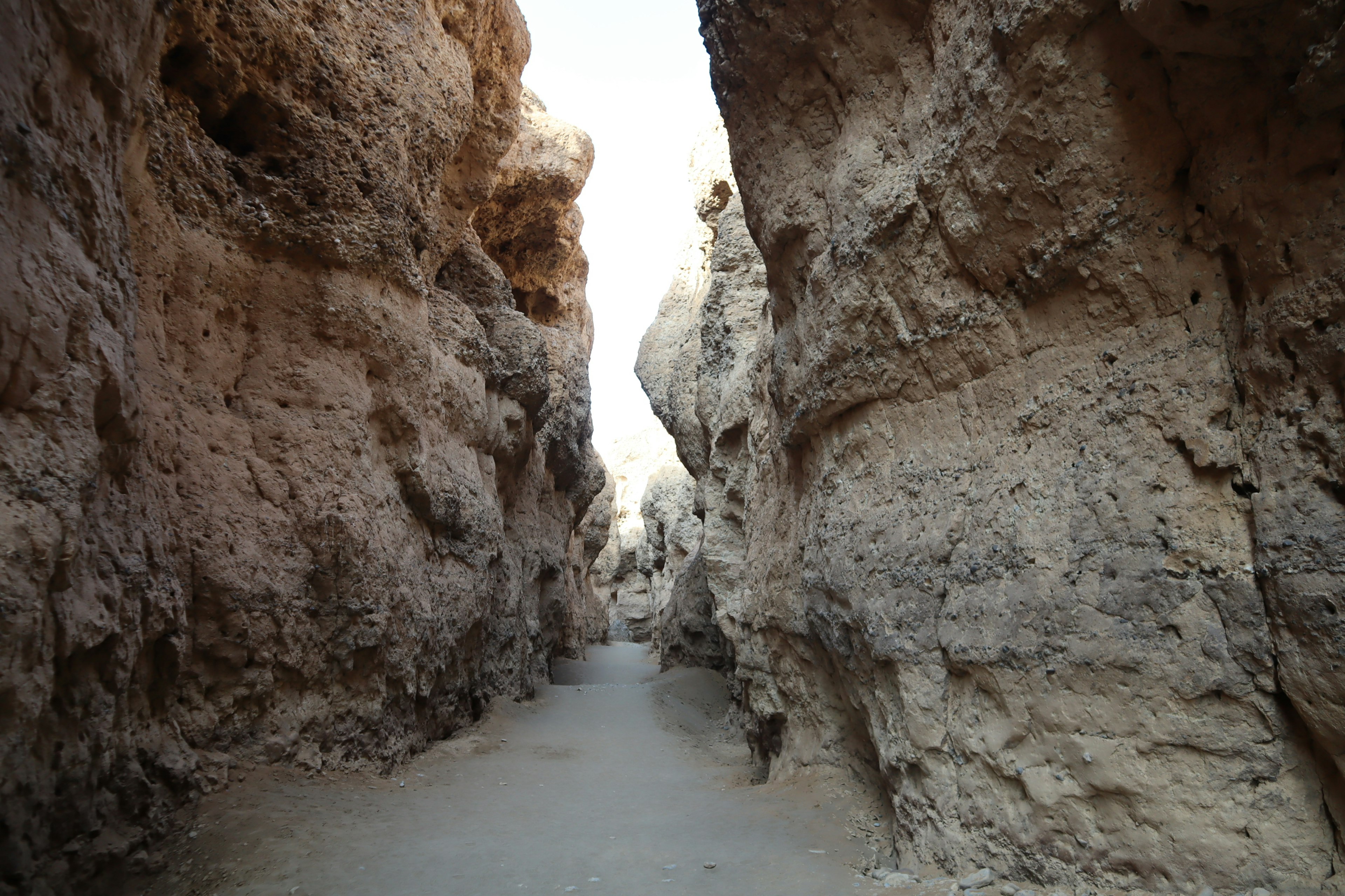 Sentiero stretto in un canyon roccioso con pareti alte