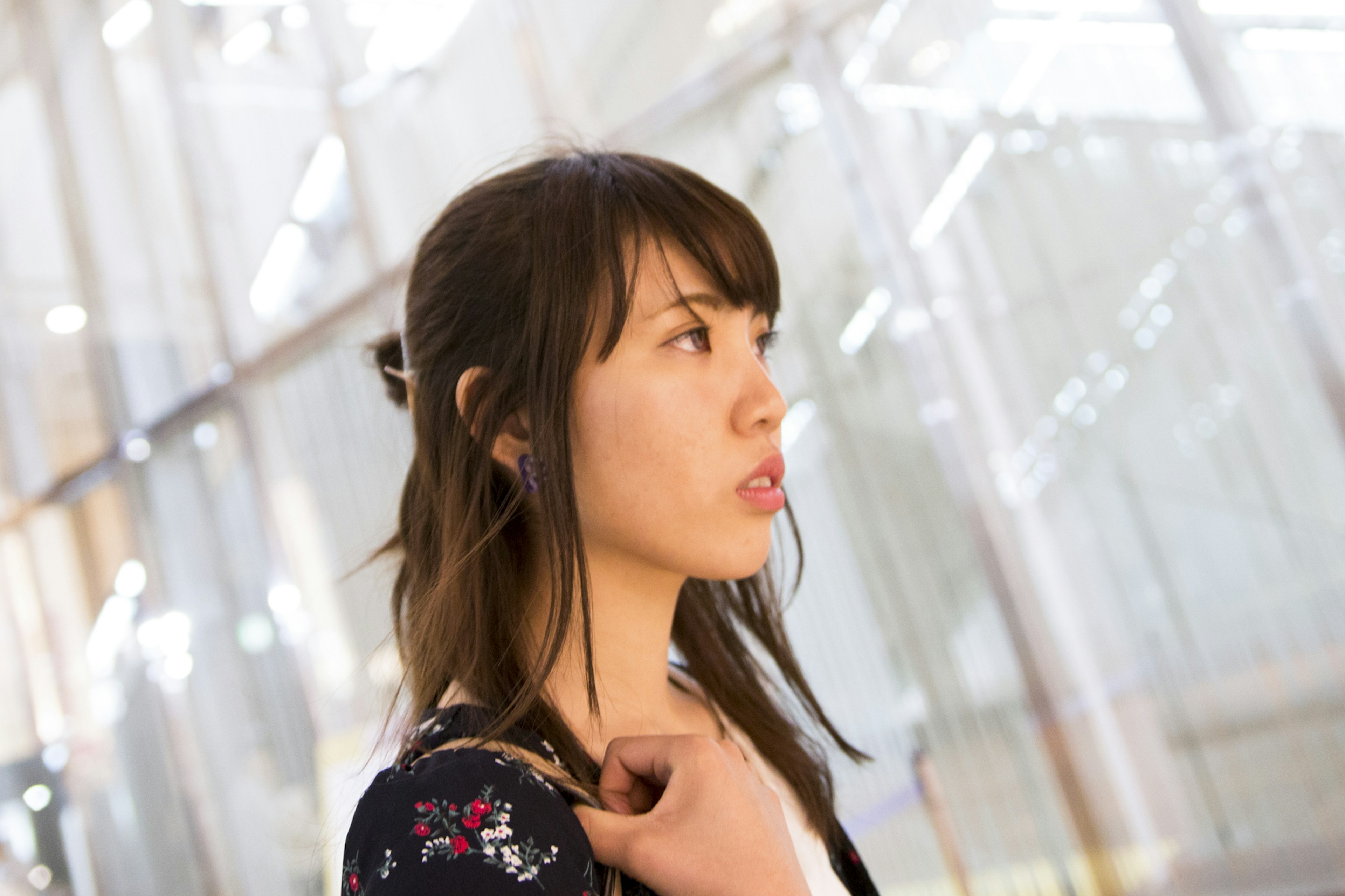 Side profile of a woman deep in thought in front of a transparent wall