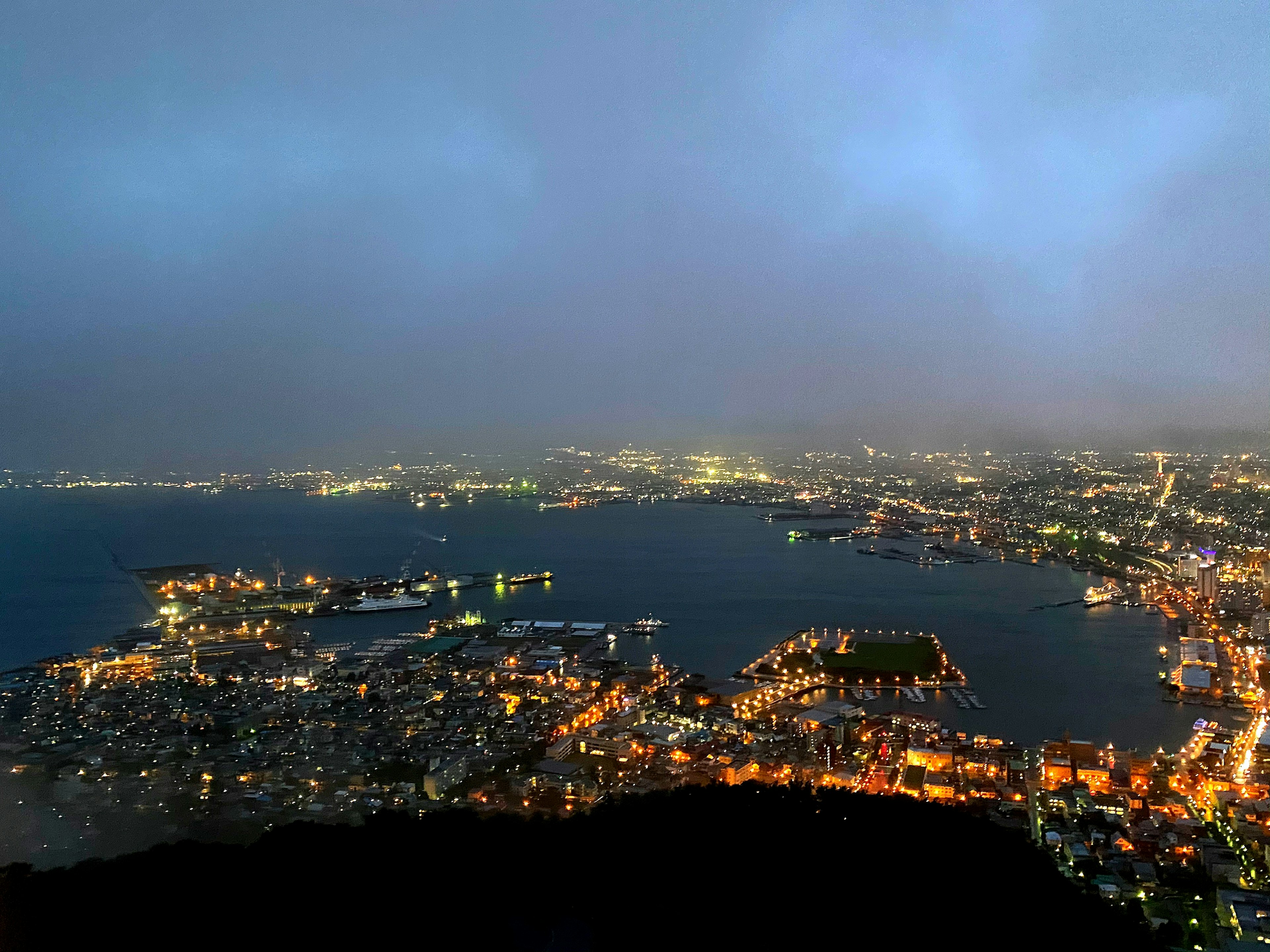 Hermosa vista nocturna de una ciudad portuaria con luces brillantes