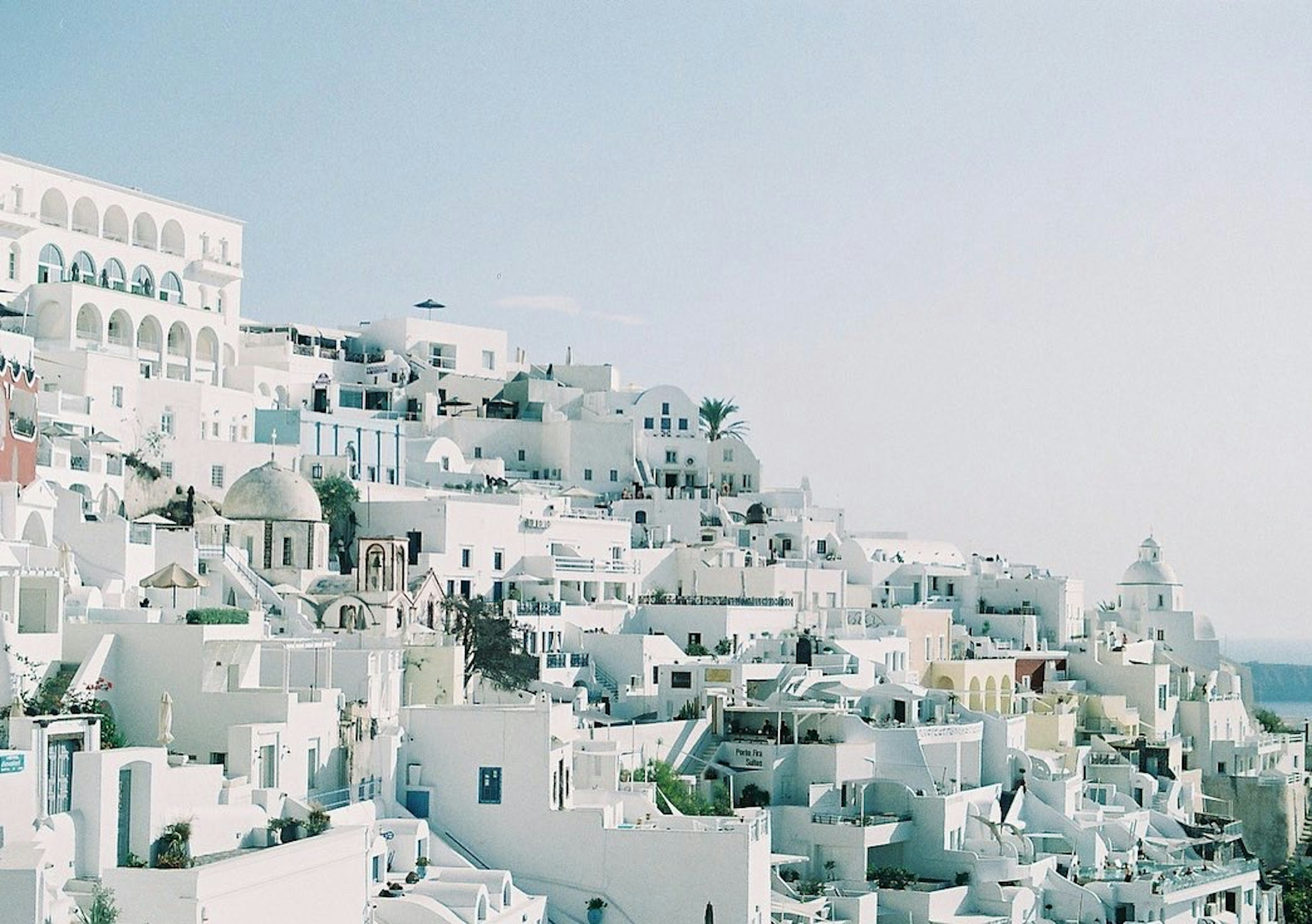 Edificios blancos de Santorini bajo un cielo azul