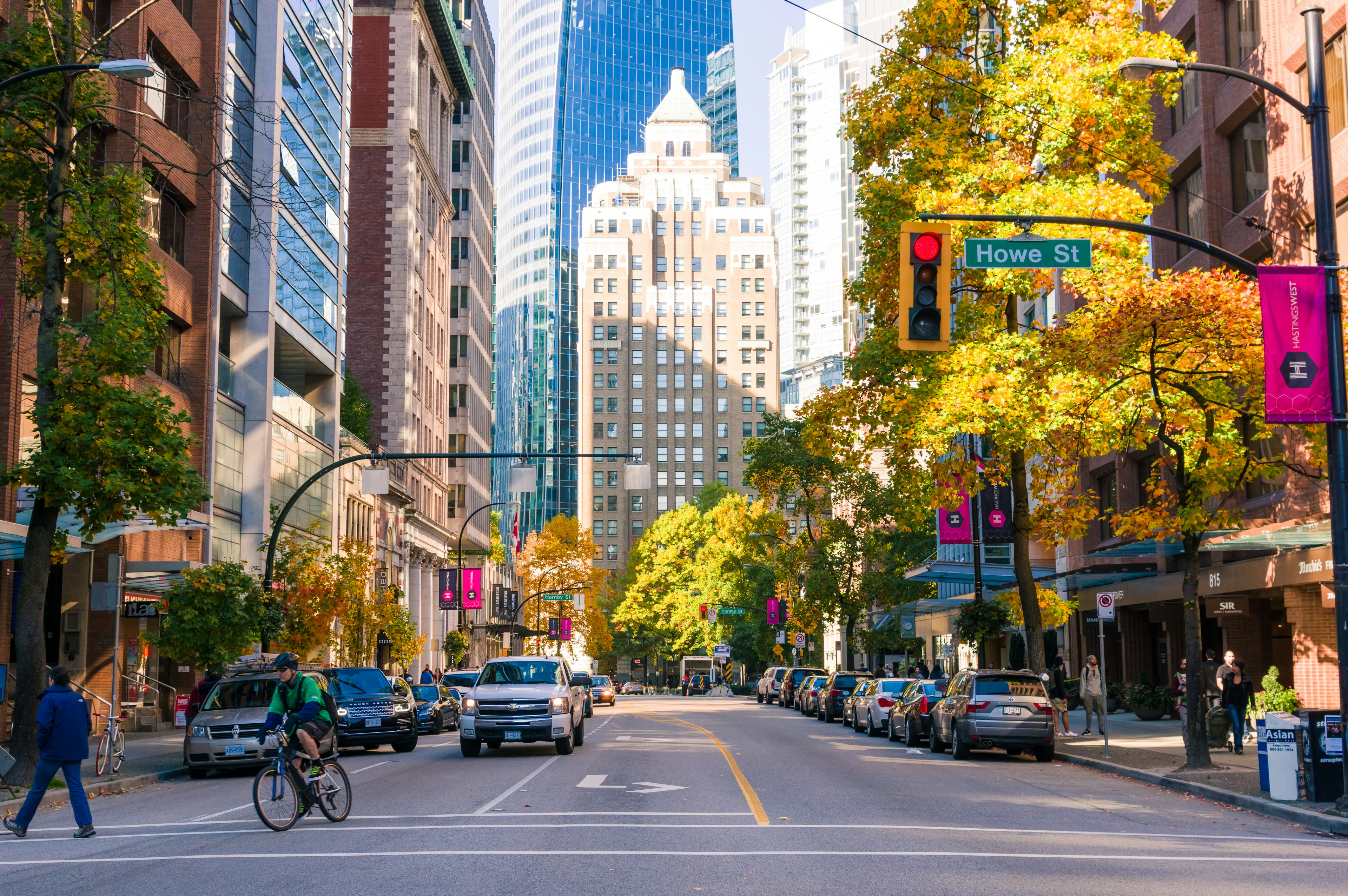 Rue de la ville en automne avec des gratte-ciels et des arbres colorés vélos et voitures visibles