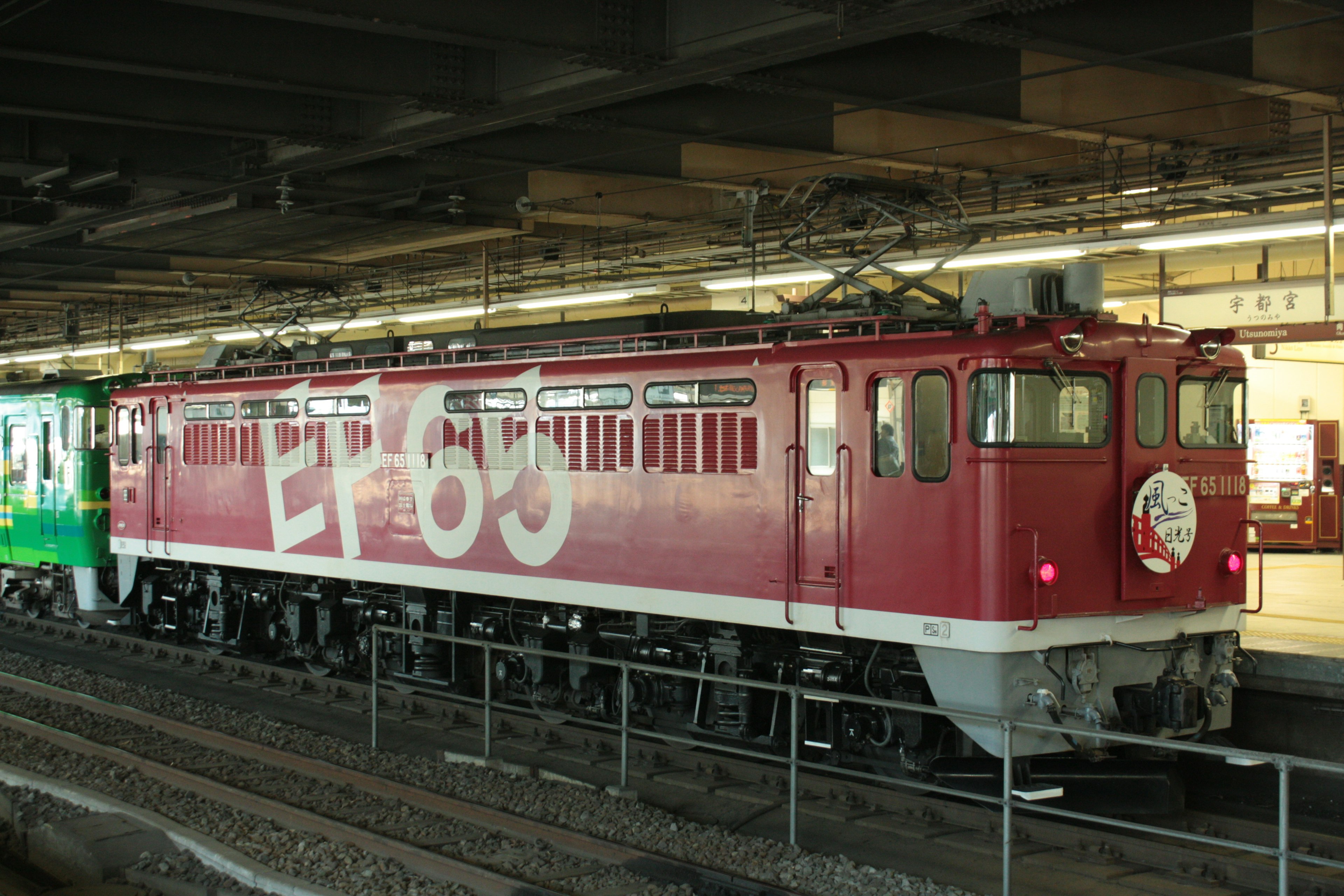 Locomotive électrique rouge EF65 garée sur le quai de la gare