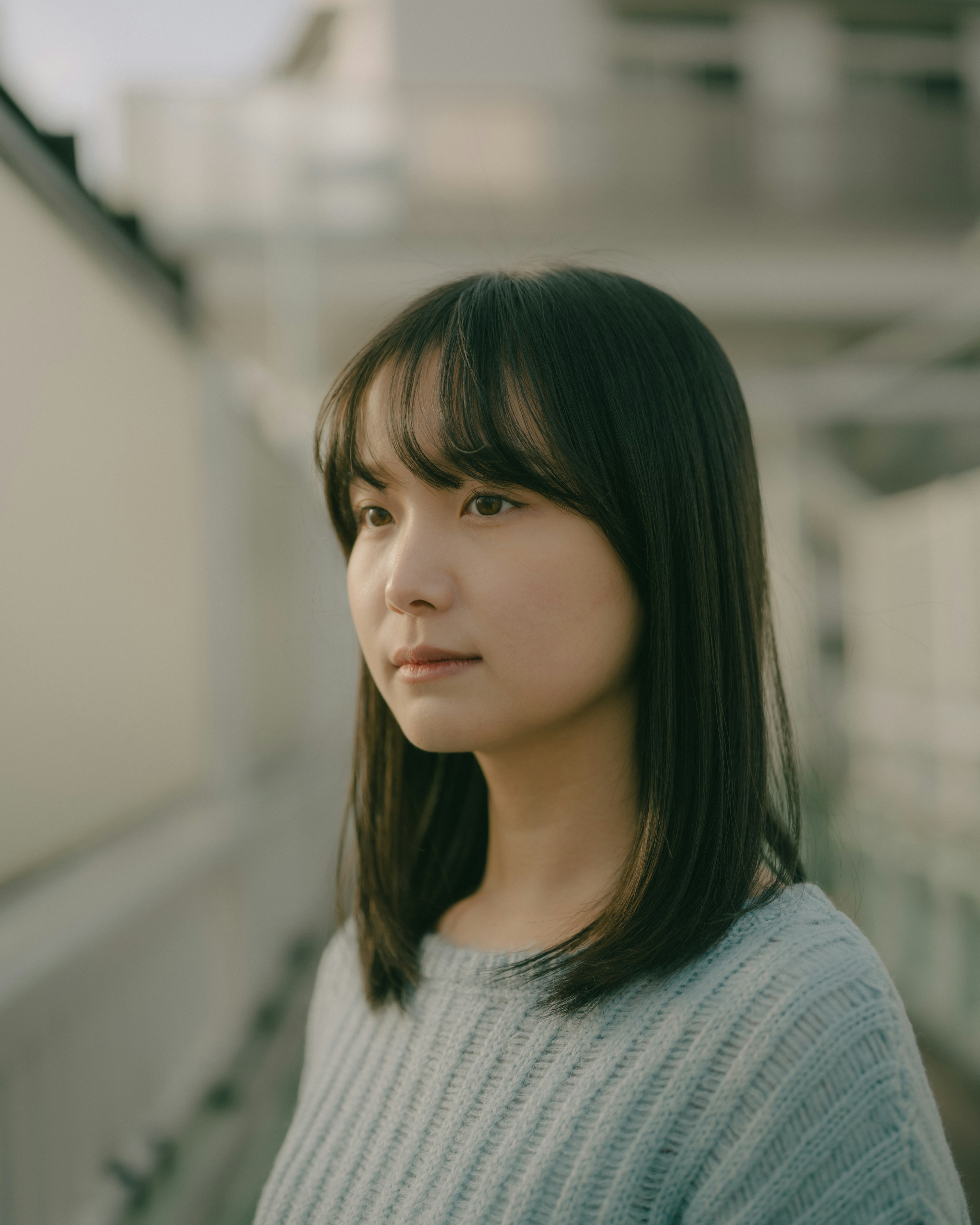 Portrait d'une femme regardant sur le côté avec une expression douce et un fond naturel