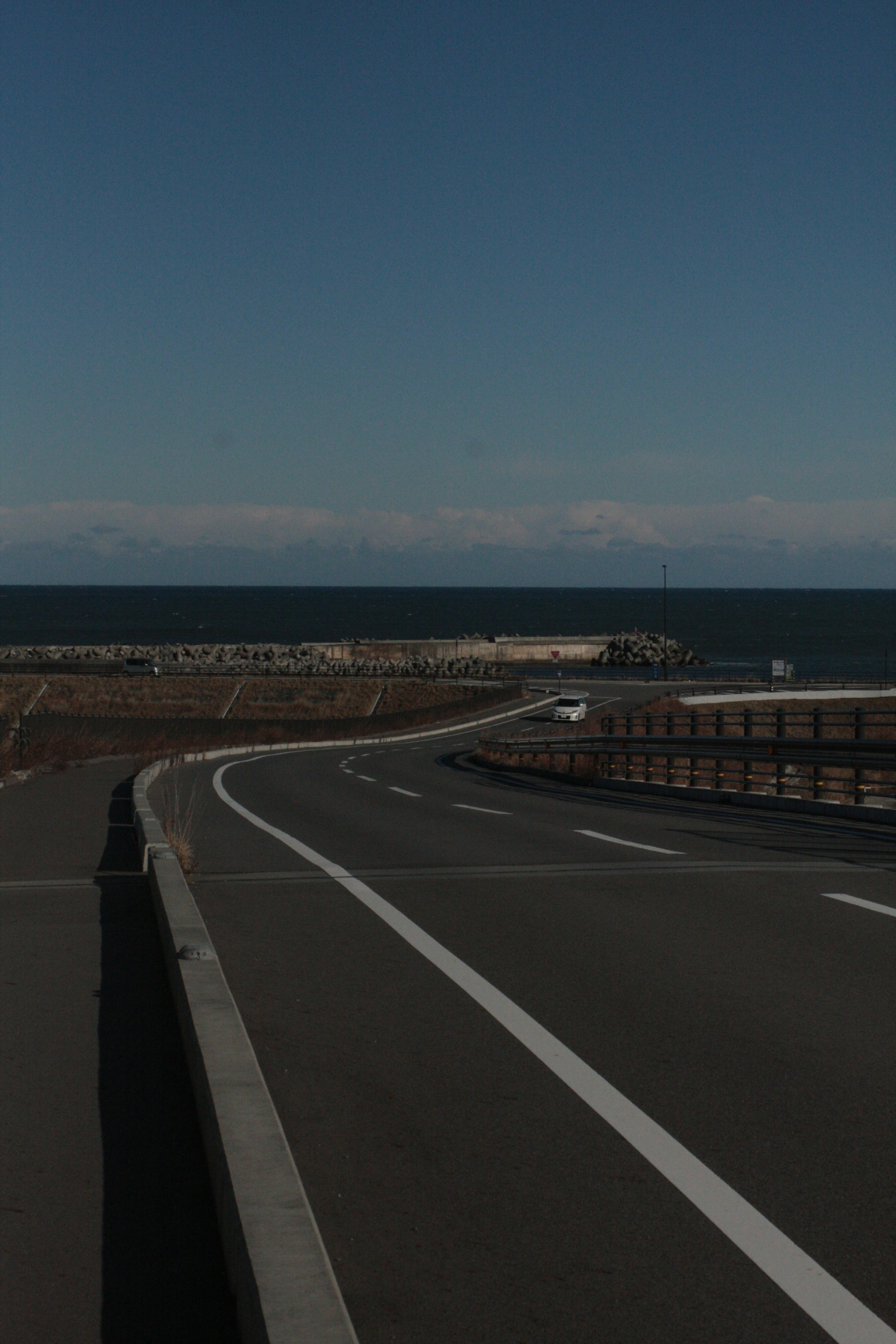 弯曲的道路俯瞰大海，清澈的蓝天